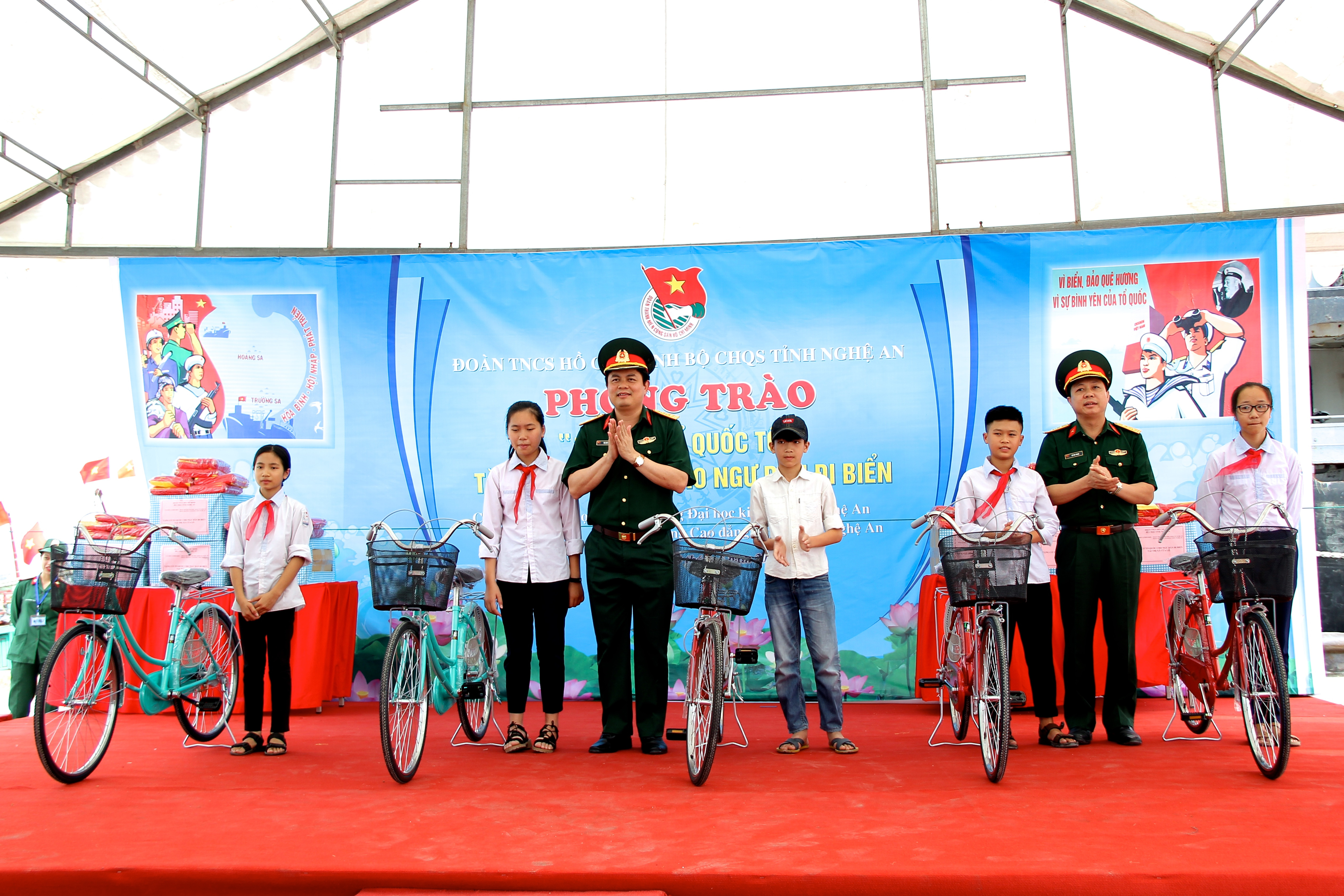 Lãnh đạo Bộ CHQS tỉnh trao tặng xe đạp cho các em học sinh nghèo học giỏi. Ảnh: Mỹ Nga 