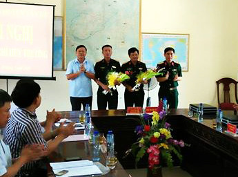 Lãnh đạo Bộ CHQS Tỉnh và huyện tặng hoa chúc mừng đồng chí. Ảnh: Nguyễn Hường
