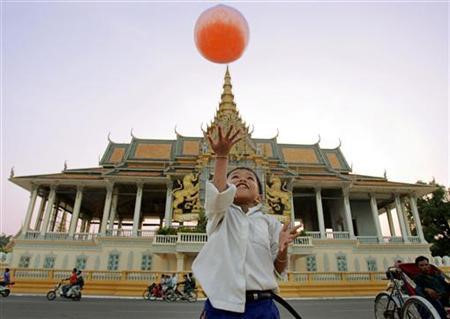 Một em bé chơi bóng trước hoàng cung Campuchia /// Reuters
