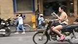 Phát hoảng với cô gái vừa đọc sách vừa lái xe máy trên đường