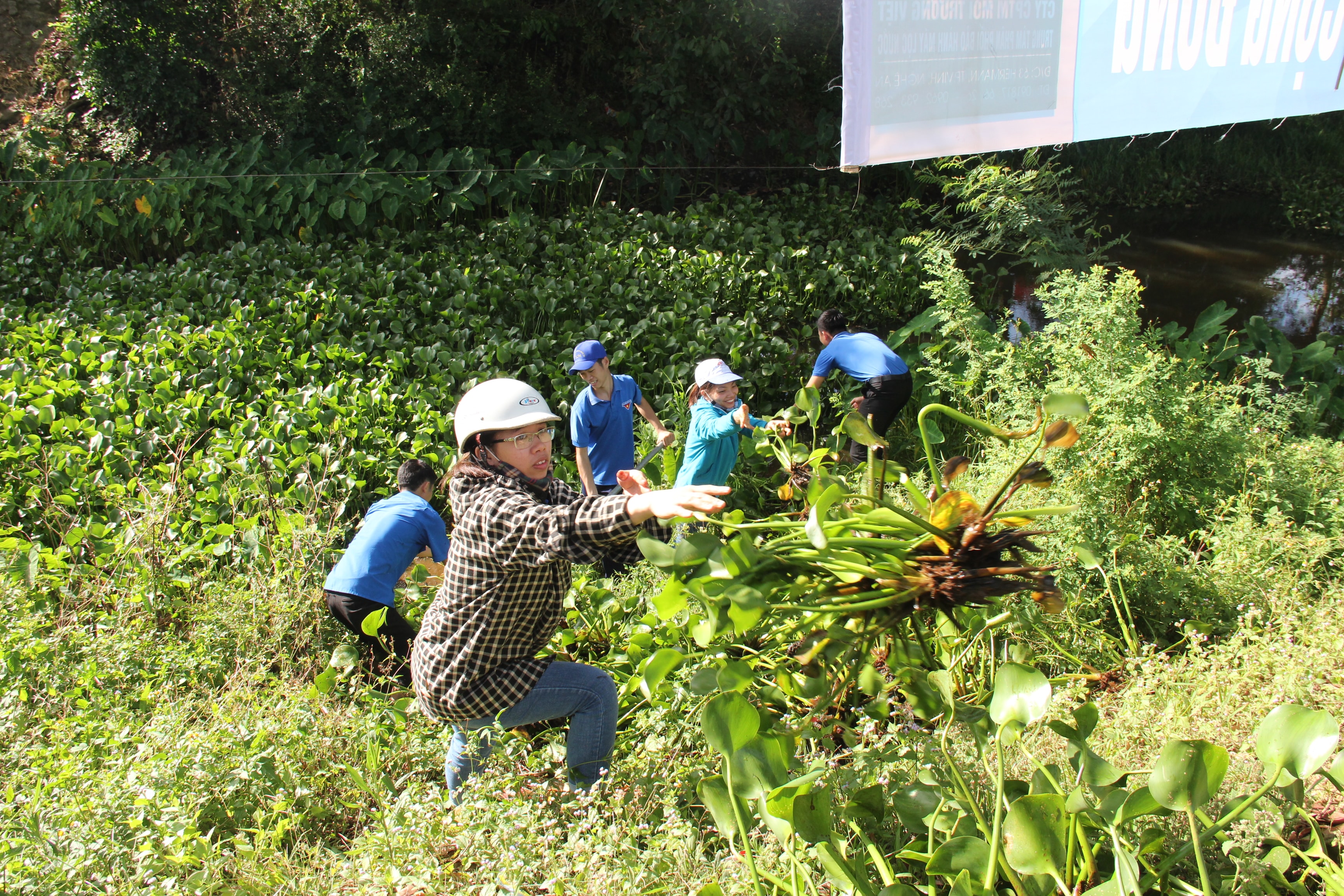 Đoàn viên thanh niên huyện Hưng Nguyên tham gia dọn dẹp khơi thông dòng chảy các tuyến kênh mương trên địa bàn xã Hưng Thông. Ảnh: Hoài Thu