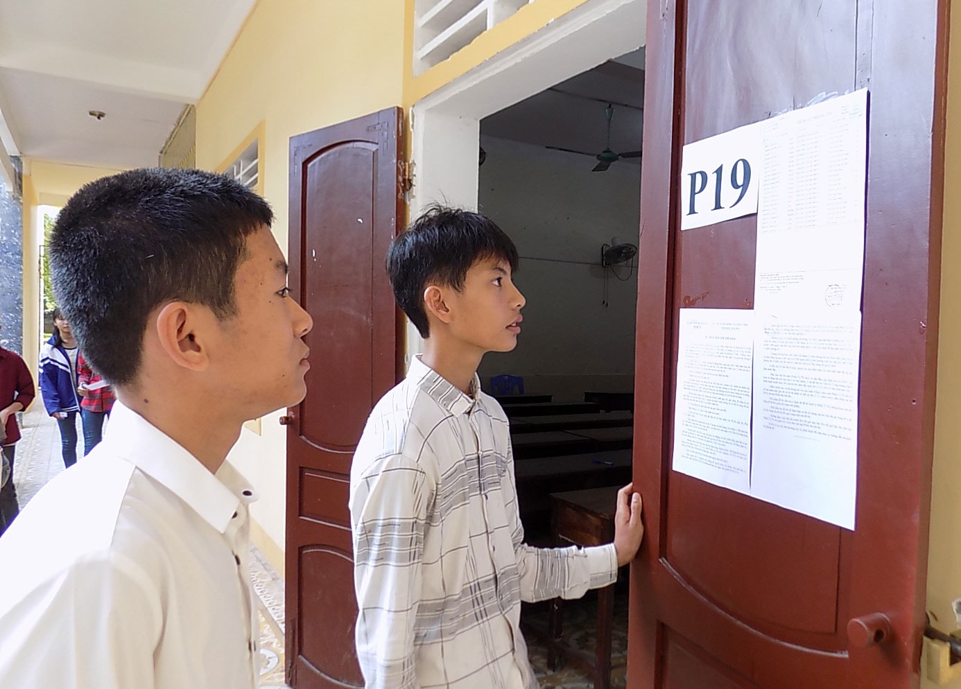 Các thí sinh xem số báo danh và quy chế trước khi vào phòng thi. Ảnh: Thu Hường