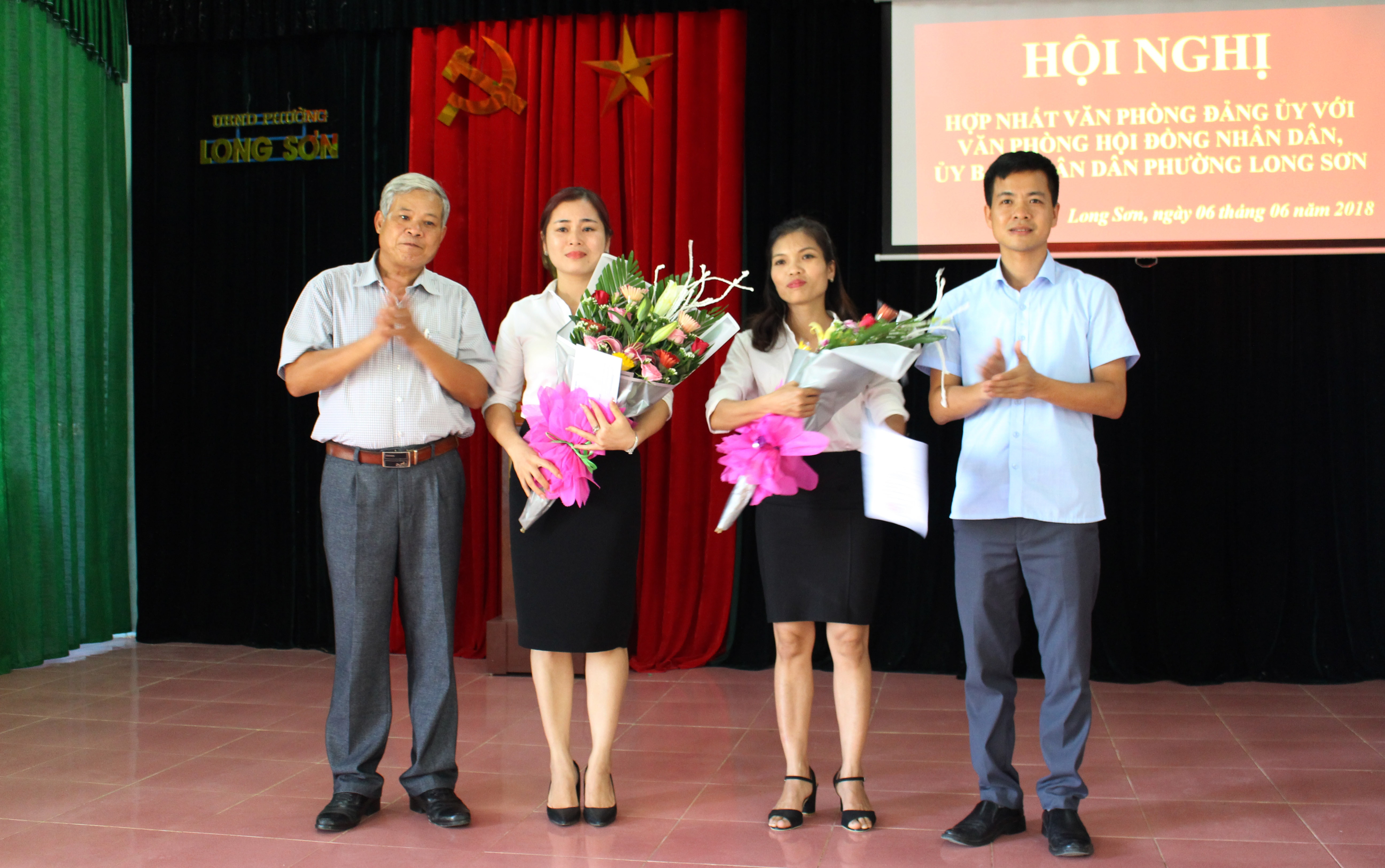 Lãnh đạo phường Long Sơn, thị xã Thái Hòa trao quyết định, tặng hoa chúc mừng các công chức nhận công tác mới. Ảnh: Hoàng Thủy