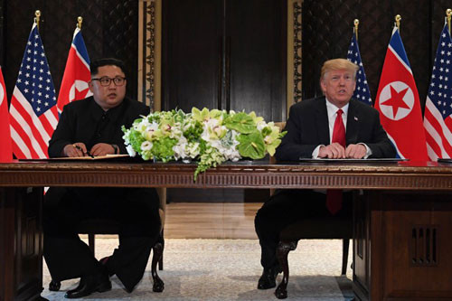 Lãnh đạo Triều Tiên Kim Jong-un và Tổng thống Mỹ Donald Trump ký tuyên bố chung tại Singapore. Ảnh: StraitsTimes.