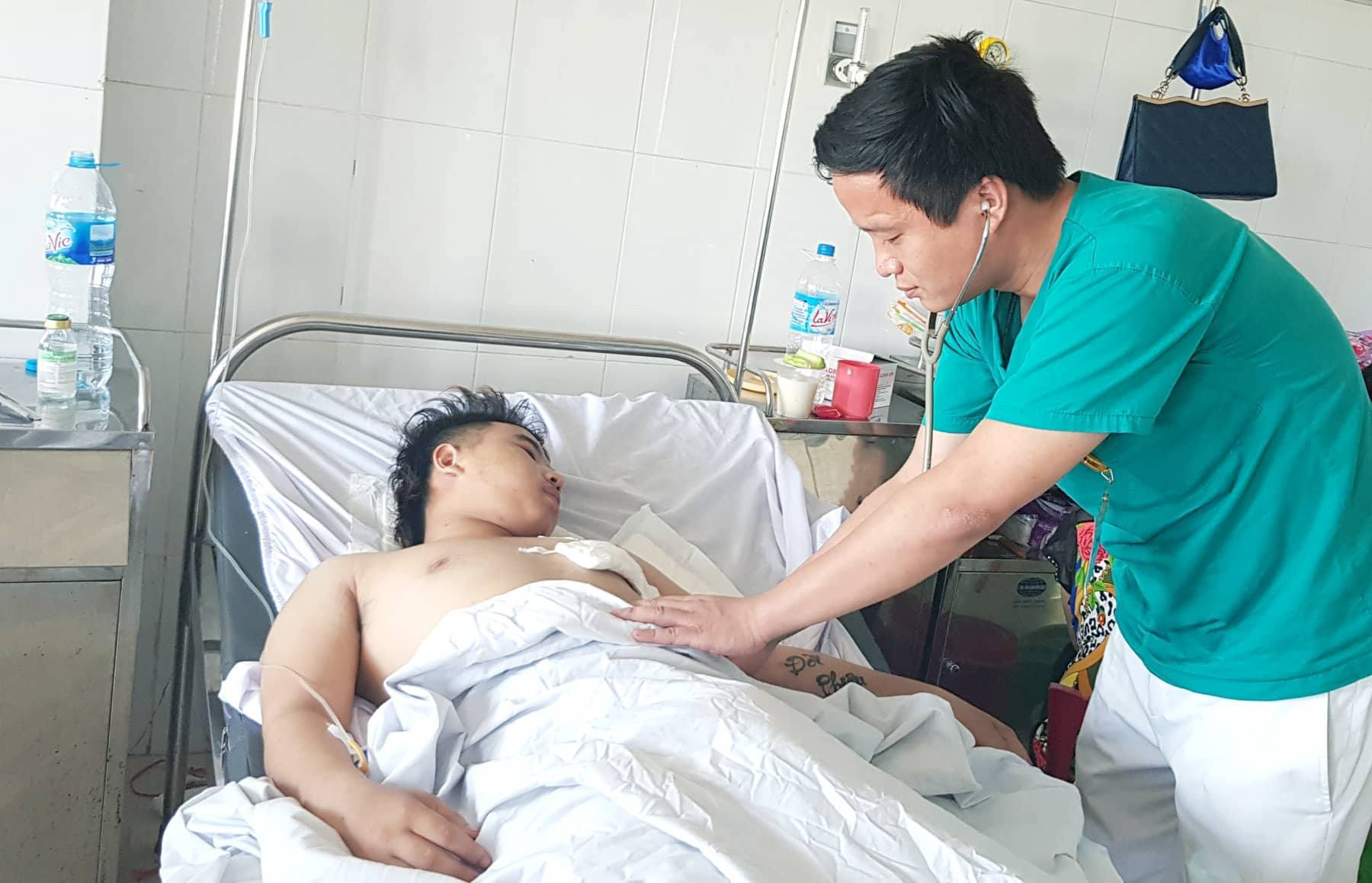 BSCKI. Hồ Thái Phúc (khoa Ngoại Lồng ngực) chăm sóc hậu phẫu mổ tim cho bệnh nhân Nguyễn Thành P. Ảnh: Hoàng Yến