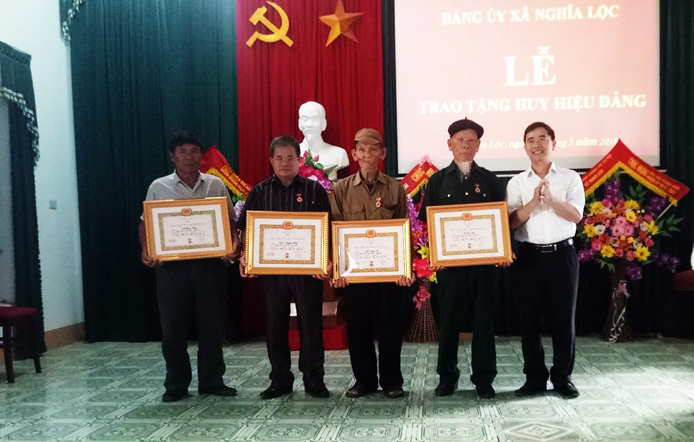 Lãnh đạo Huyện ủy Nghĩa Đàn trao Huy hiệu Đảng cho các đảng viên. Ảnh: Minh Thái