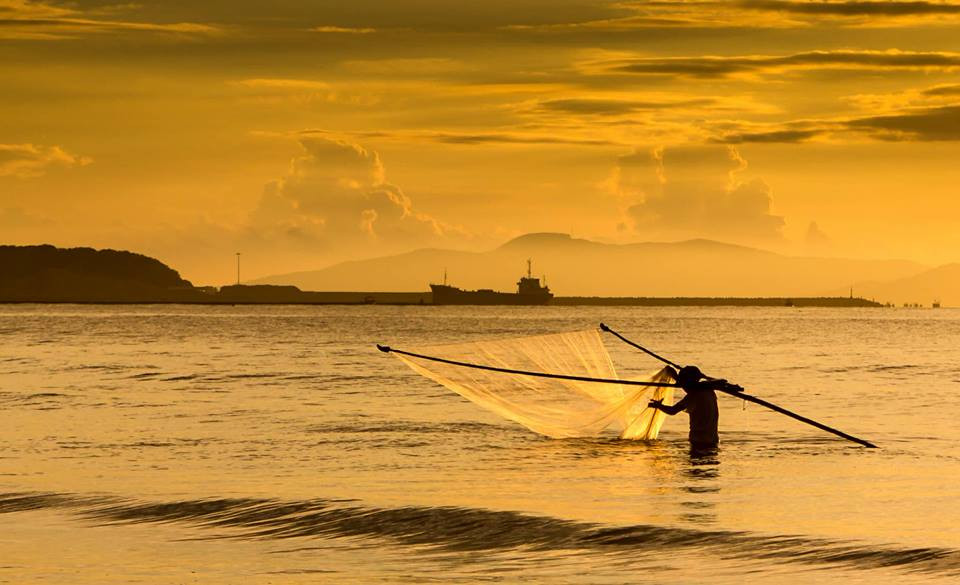Ngư dân thả lưới trong ánh nắng sáng mai ở xóm biển Tân Minh. Ảnh: Duy Sơn