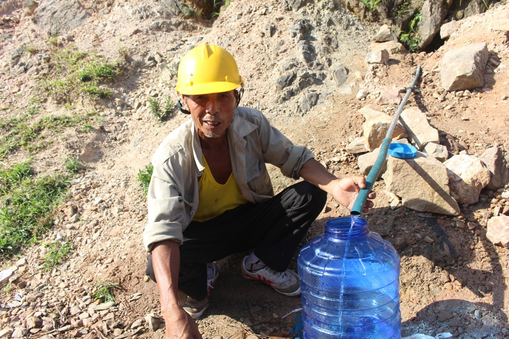  Trong chân núi, người dân đặt 1 vòi nhựa dài hơn 2 mét bắt ra ngoài để bà con lấy nước. Ảnh: Việt Hùng.