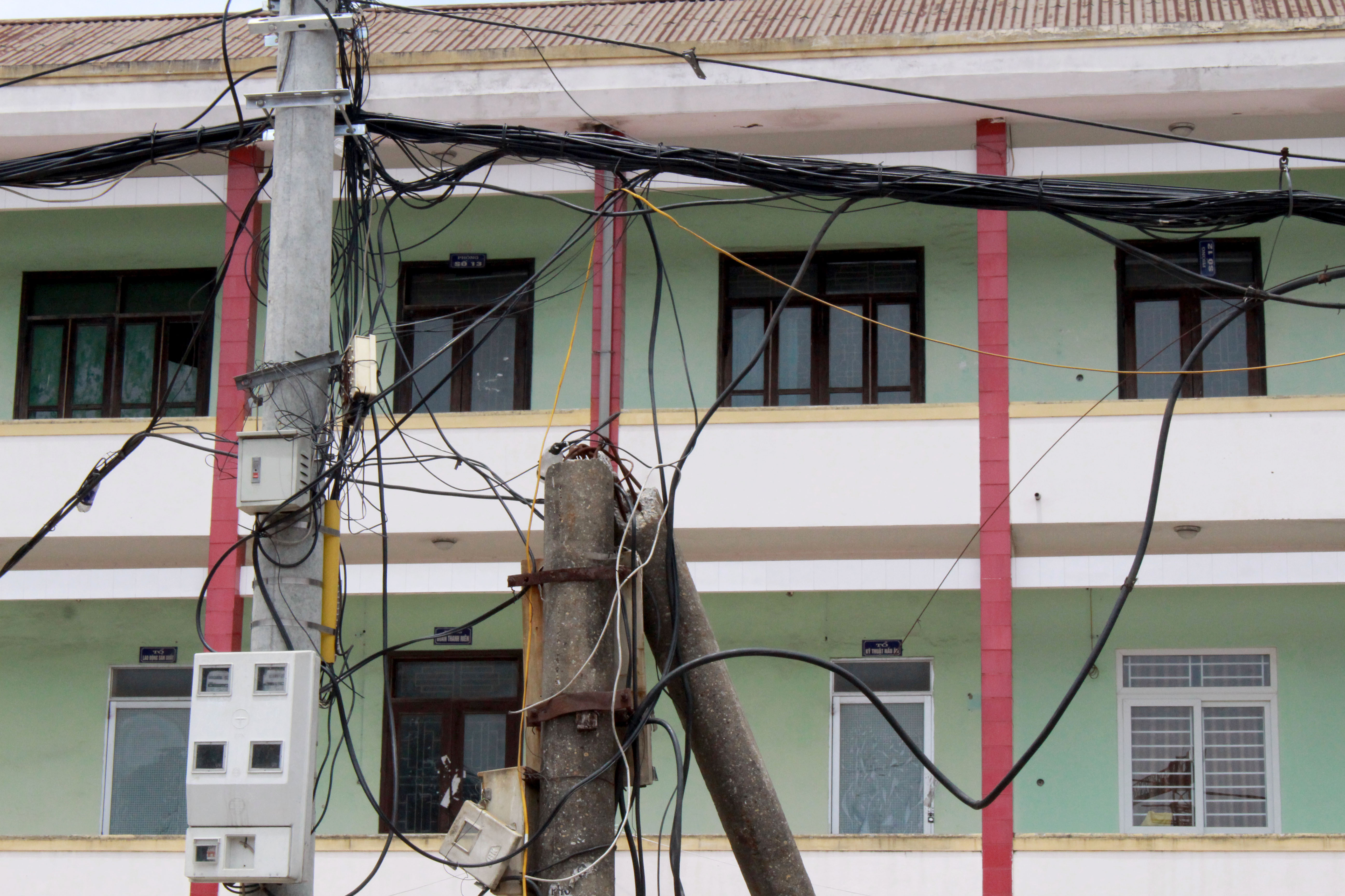 Cột điện tại số 247, đường Lê Duẩn (khối 13, phường Trung Đô) bị gãy sau bão số 10, năm 2017, đã được thay thế cột mới nhưng cột điện cũ vẫn chưa được tháo dỡ và hệ thống dây điện, dây viễn thông đang bị võng xuống.Ảnh:Đinh Nguyệt