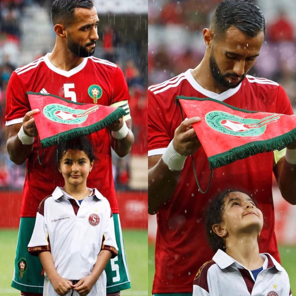 Giây phút đội trưởng đội tuyển Morocco, Medhi Benatia dùng lá cờ hiệu che mưa cho bé gái đại diện cho anh trên sân cỏ trong một trận đá giao hữu trước thềm World Cup 2018