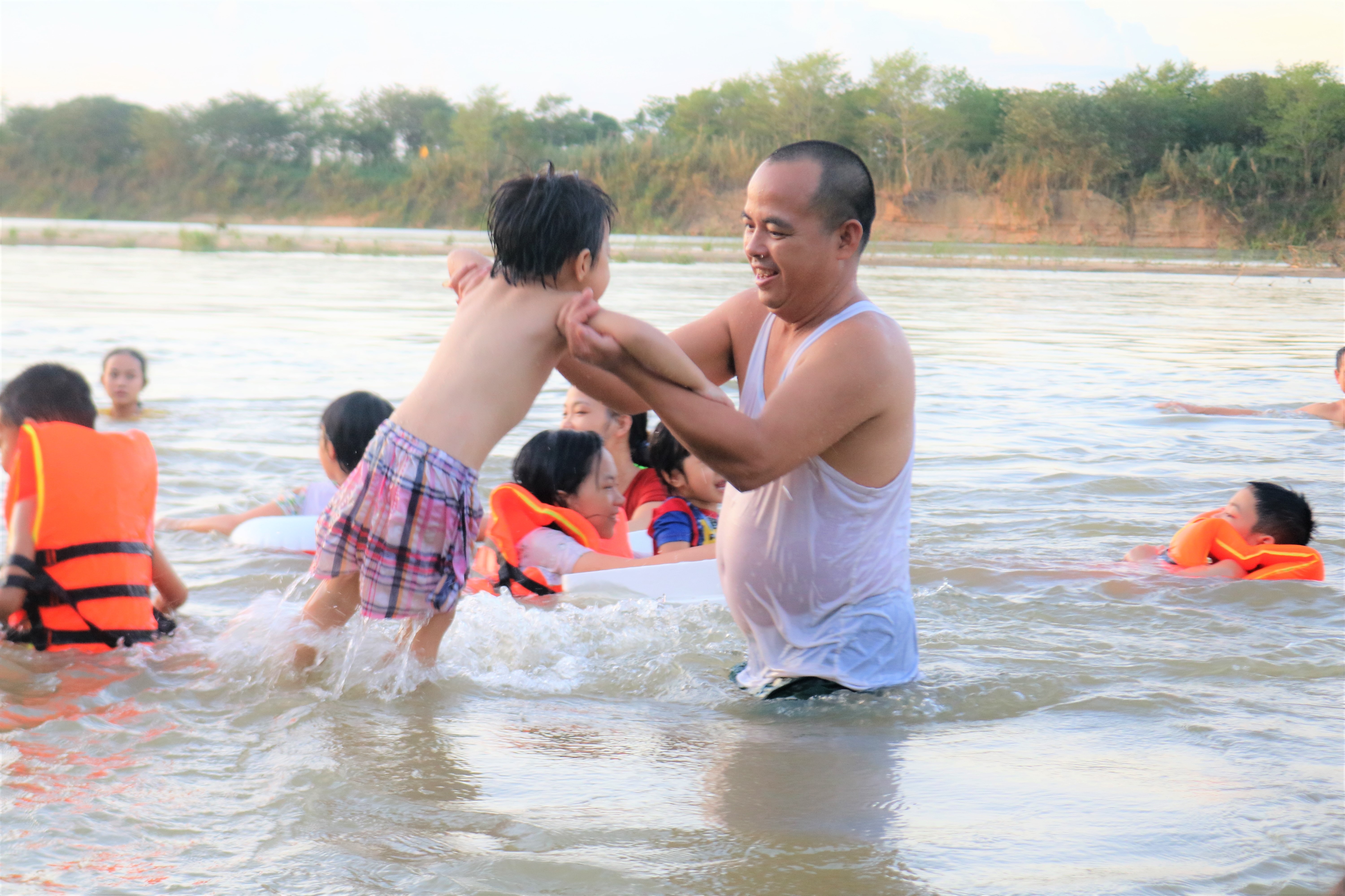 Trẻ em được tắm dưới sự bảo vệ của người lớn. Ảnh: Diệp Phương