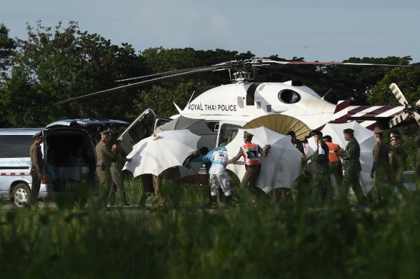 Giới chức dùng ô che cáng được vận chuyển từ trực thăng tới xe cứu thương. Ảnh: Reuters.