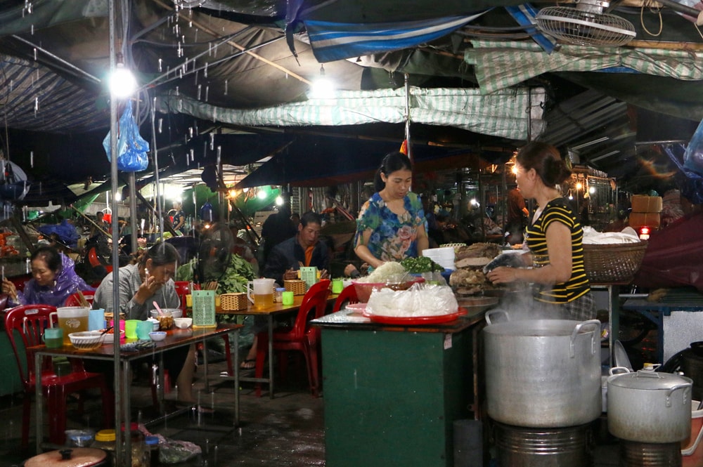 Một quán ăn nhỏ trong chợ cũng trở nên tập nập khi phục vụ ăn sáng cho những người kinh doanh trong chợ cũng như các nhà xe tranh thủ khi cơn mưa ập đến. Ảnh: Ngọc Quý