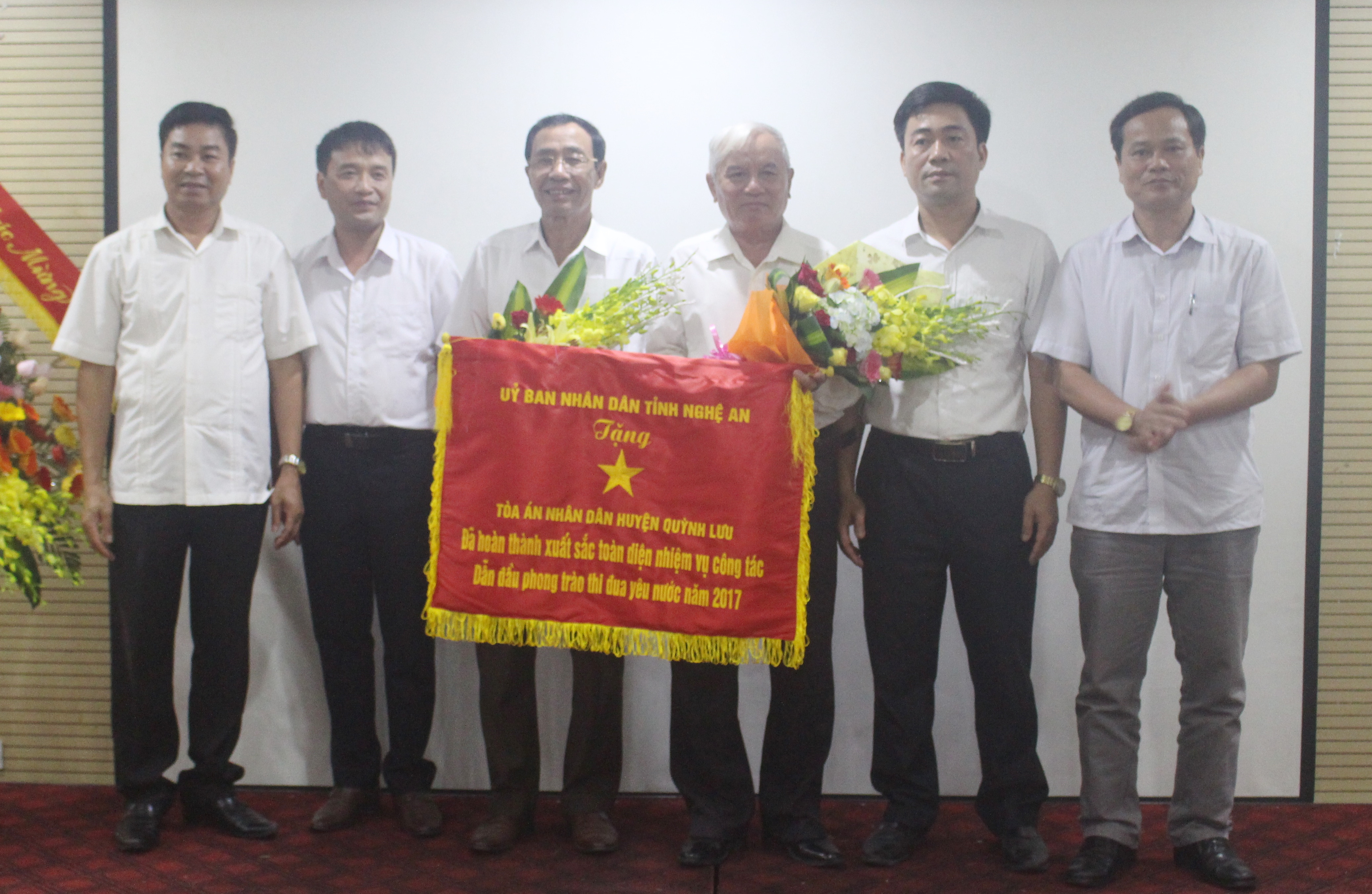 Tập thể Tòa án nhân dân huyện Quỳnh Lưu nhận cờ thi đua của UBND tỉnh dẫn đầu phong trào thi đua tỉnh Nghệ An năm 2017. Ảnh: Thanh Nhàn
