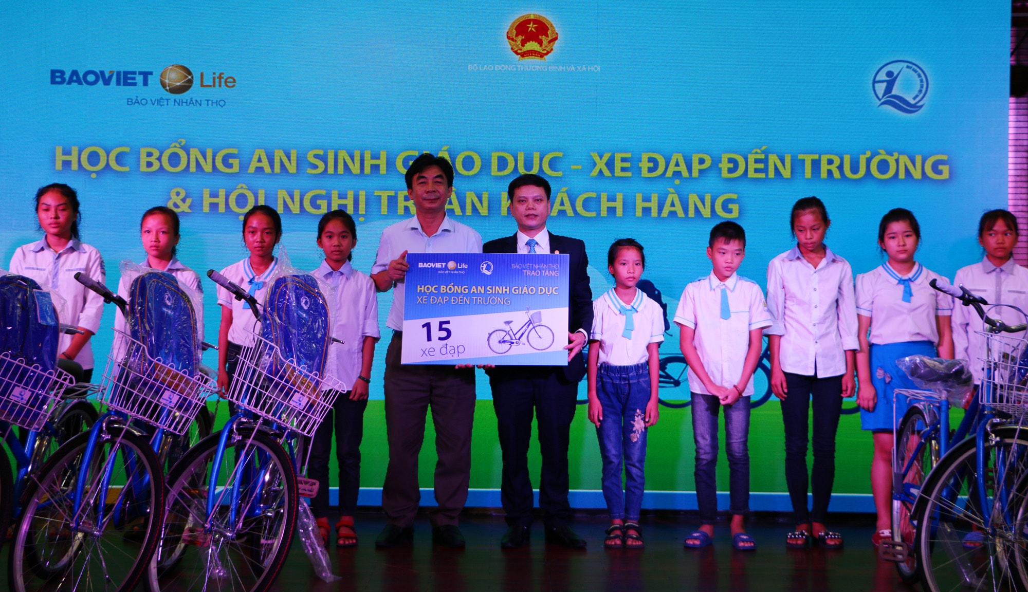Ông Hoàng Công Sáng - Giám đốc Công ty Bảo Việt Nhân thọ Bắc Nghệ An và lãnh đạo huyện trao quà, chụp ảnh lưu niệm với các em học sinh nghèo hiếu học. Ảnh: Nguyễn Hải 