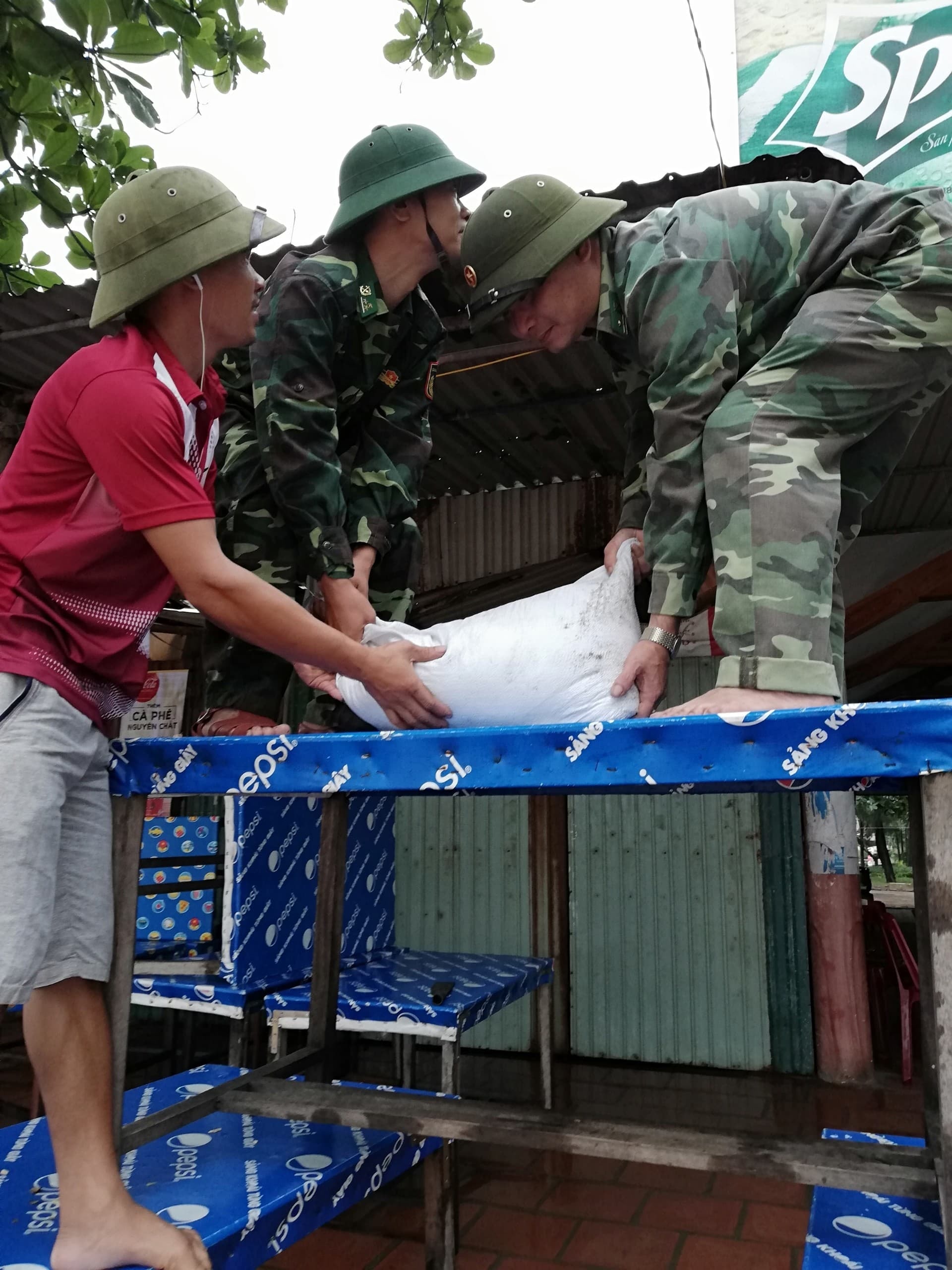 Cán bộ đồn Biên phòng cảng Cửa lò - Bến Thủy giúp dân chằng chống nhà cửa. Ảnh: Hải Thượng