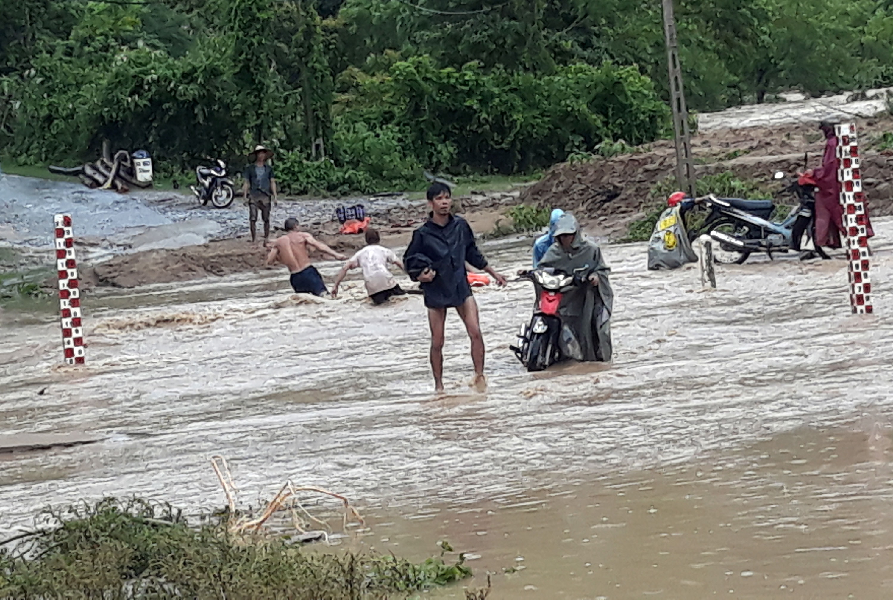 Tuy nhiên một số người cũng mạo hiểm khiêng xe qua với sự giúp đỡ của nhiều người khác. Ảnh: Đào Thọ