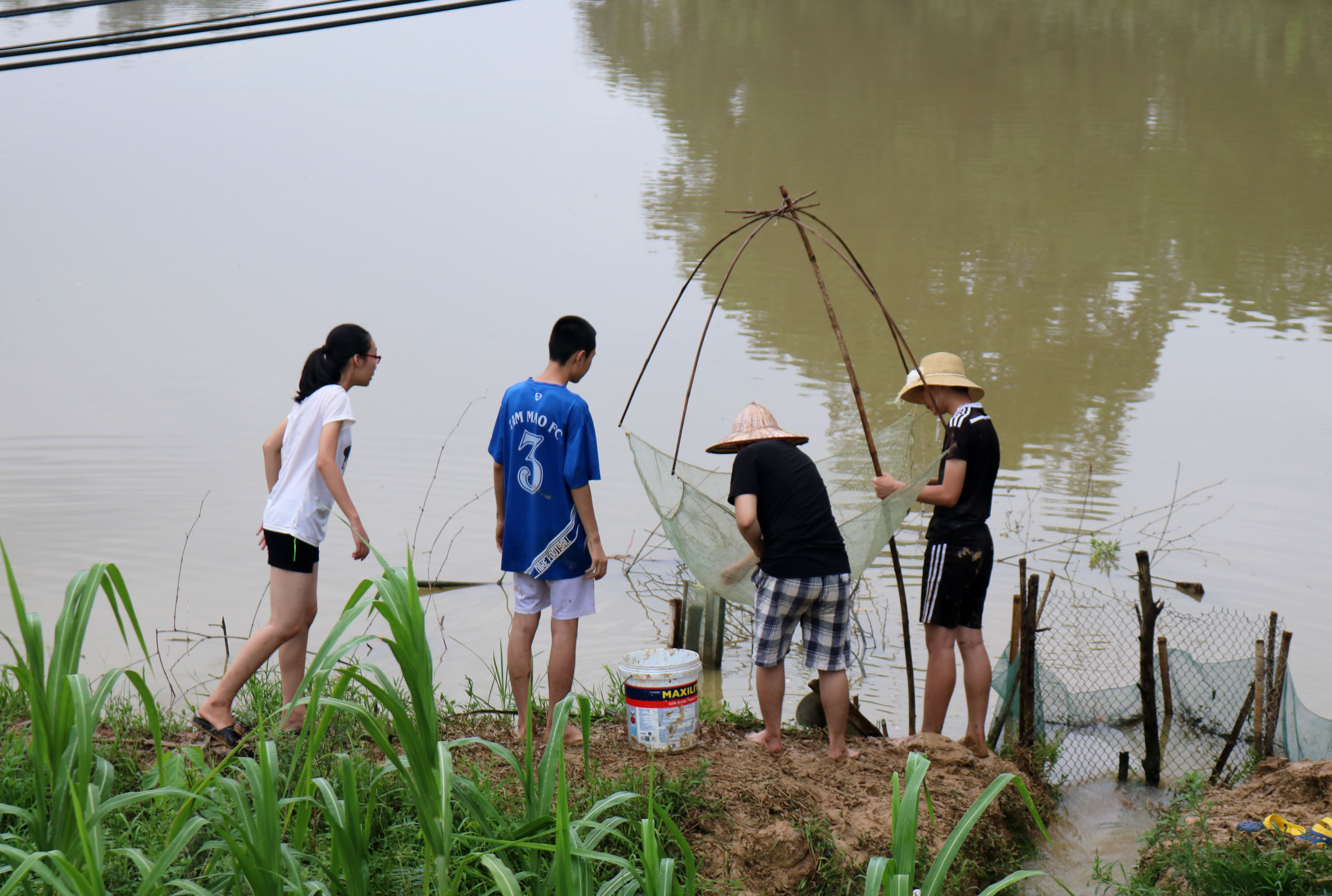 Thanh niên, sinh viên lây ngày về quê, dịp này cũng thích thú mang vó, rớ, ra đồng kiếm cá. Ảnh: Huy Thư