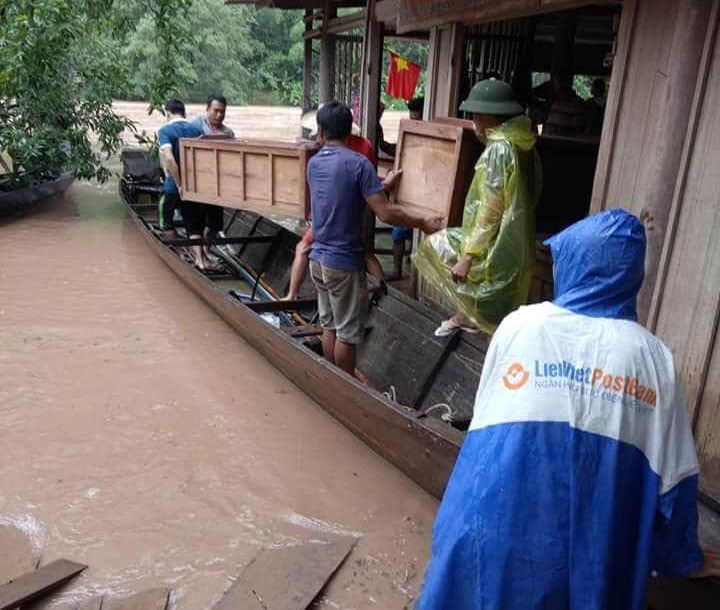 Nhanh chóng dùng thuyền bơi vào nhà di chuyển đồ đạc đến nơi an toàn. Ảnh: Đào Thọ