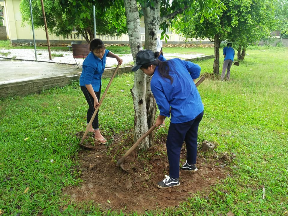 Các ĐVTN dọn vệ sinh, vun gốc cây trong khuôn viên Đài tưởng niệm liệt sỹ. Ảnh: Nguyễn Hường