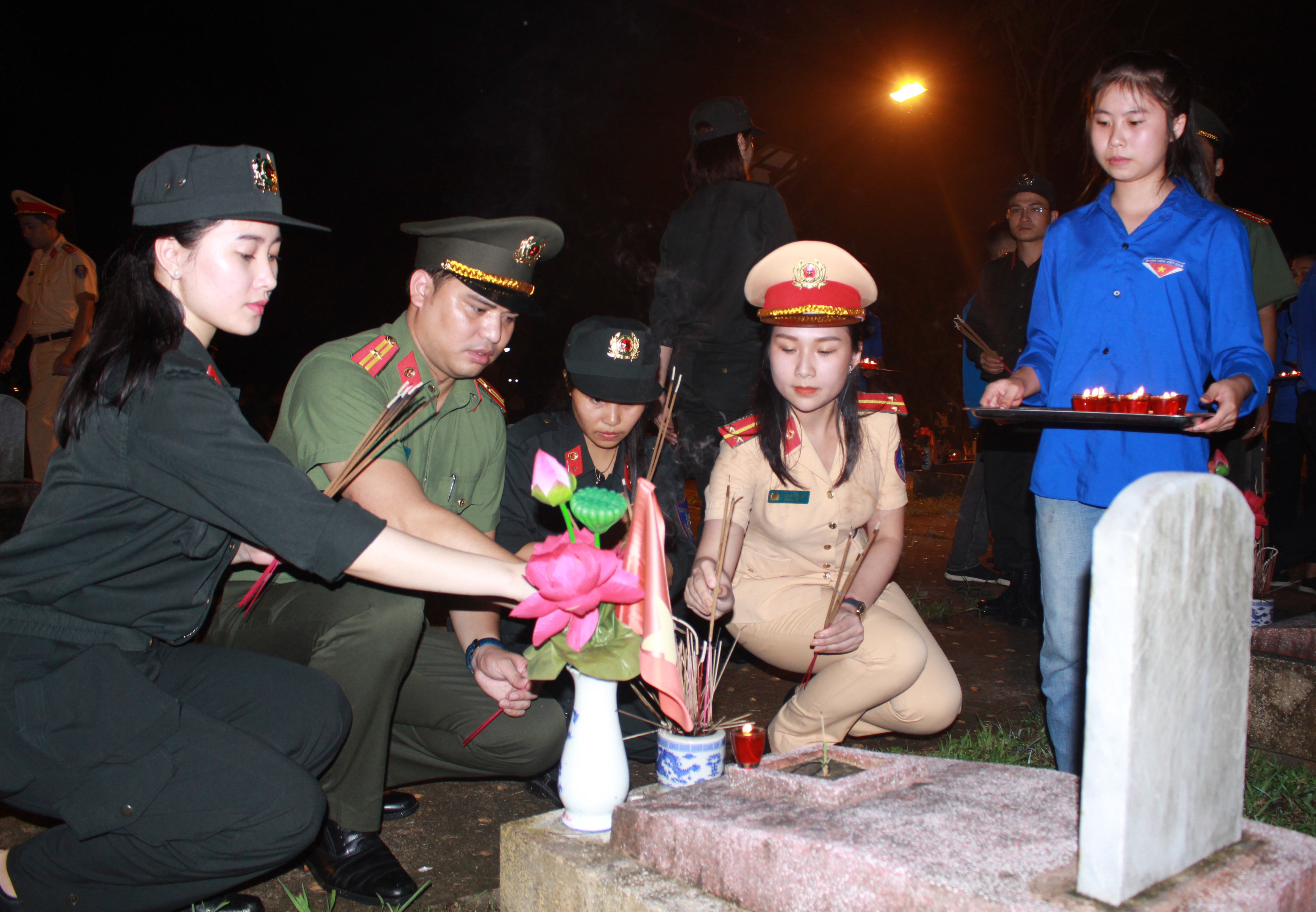 Các chiến sỹ công an thắp hương tại nghĩa trang liệt sỹ quốc tế huyện Đô Lương. Ảnh: Phương Thúy