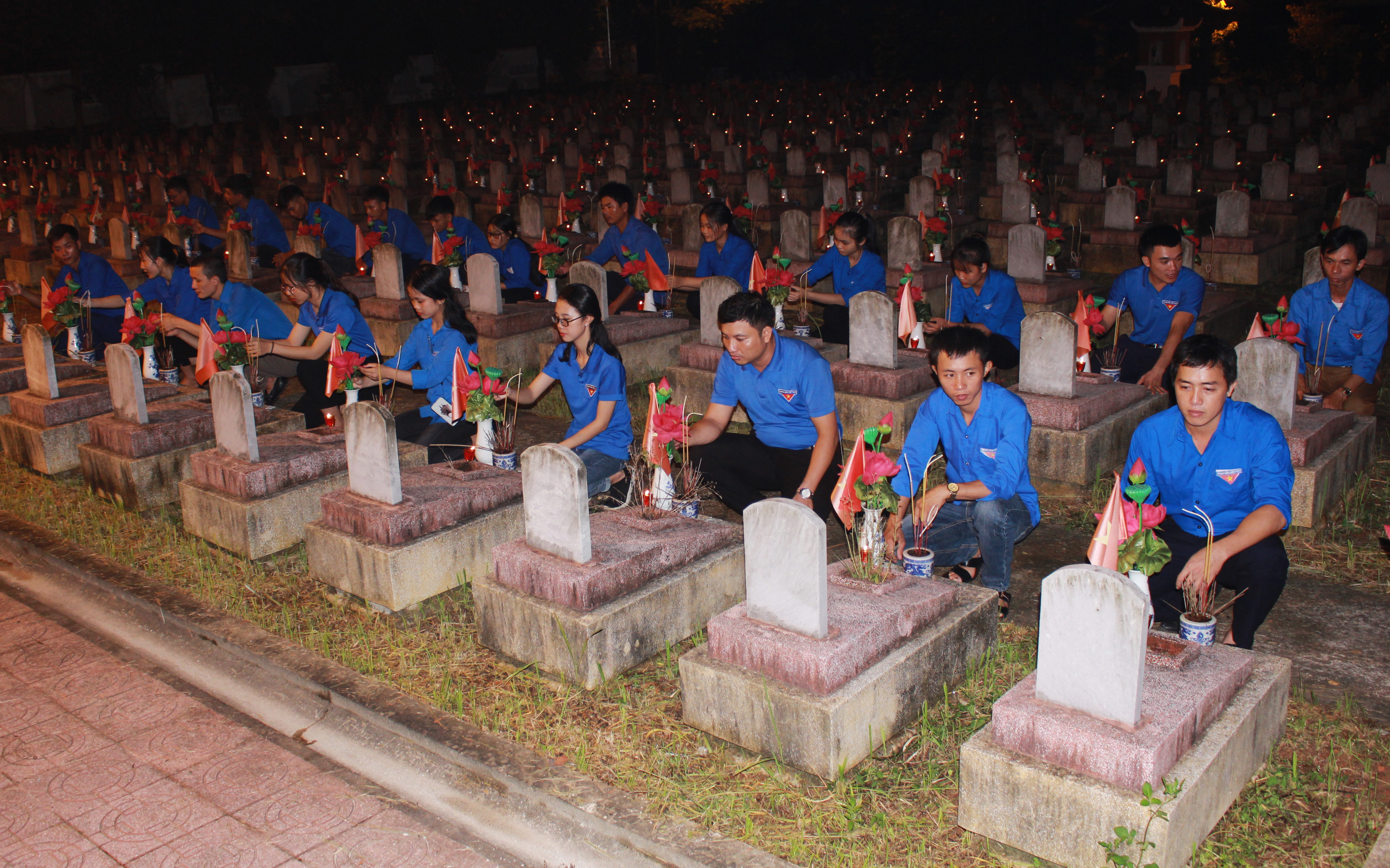 Đoàn viên thanh niên thắp nến, dâng hương tại Nghĩa trang liệt sỹ Quốc tế huyện Đô Lương. Ảnh: Phương Thúy
