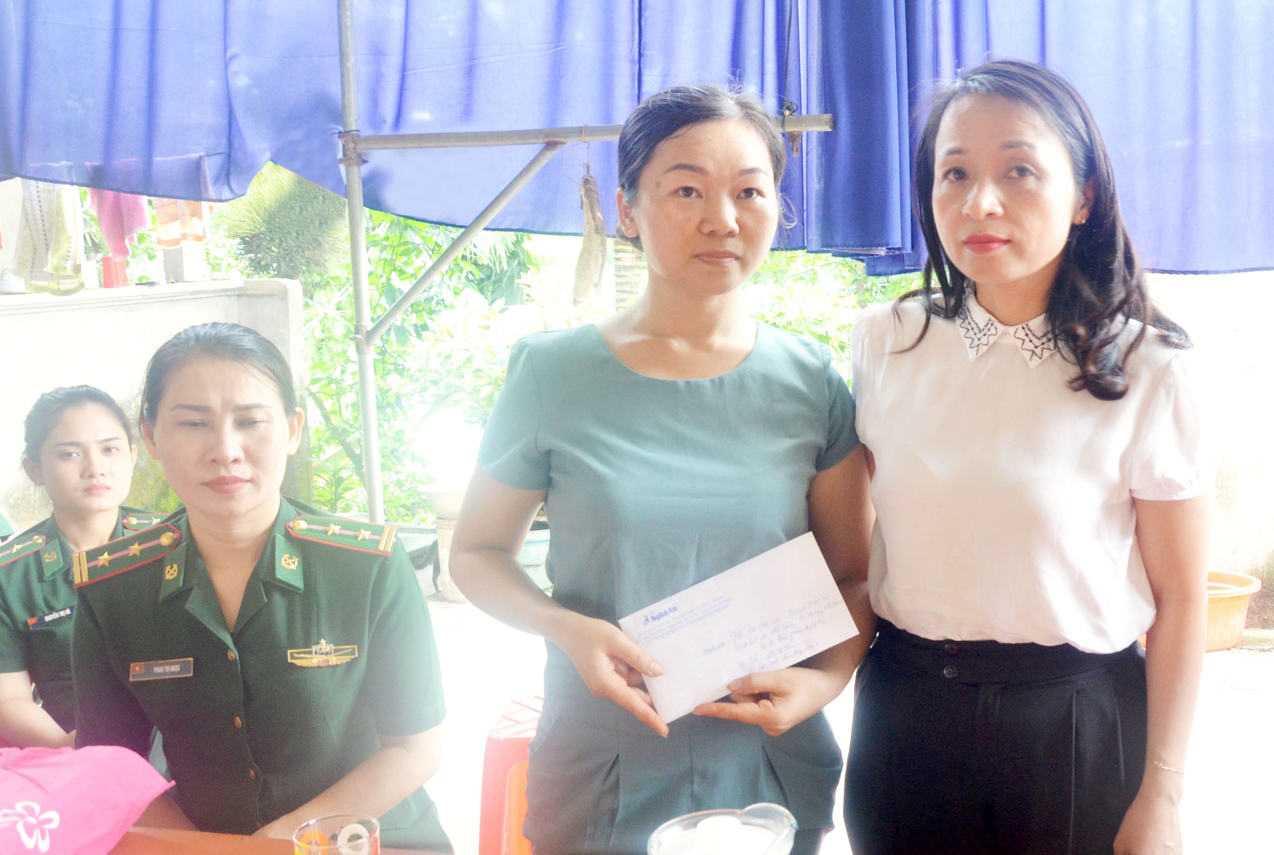 Đồng chí Phạm Thị Hồng Toan-  Ban chấp hành Đảng bộ tỉnh- Tổng biên phòng Báo Nghệ An trao số tiền hỗ trợ 25 triệu đồng cho gia đình Đại úy Nguyễn Đình Tài. Ảnh: Thu Hương