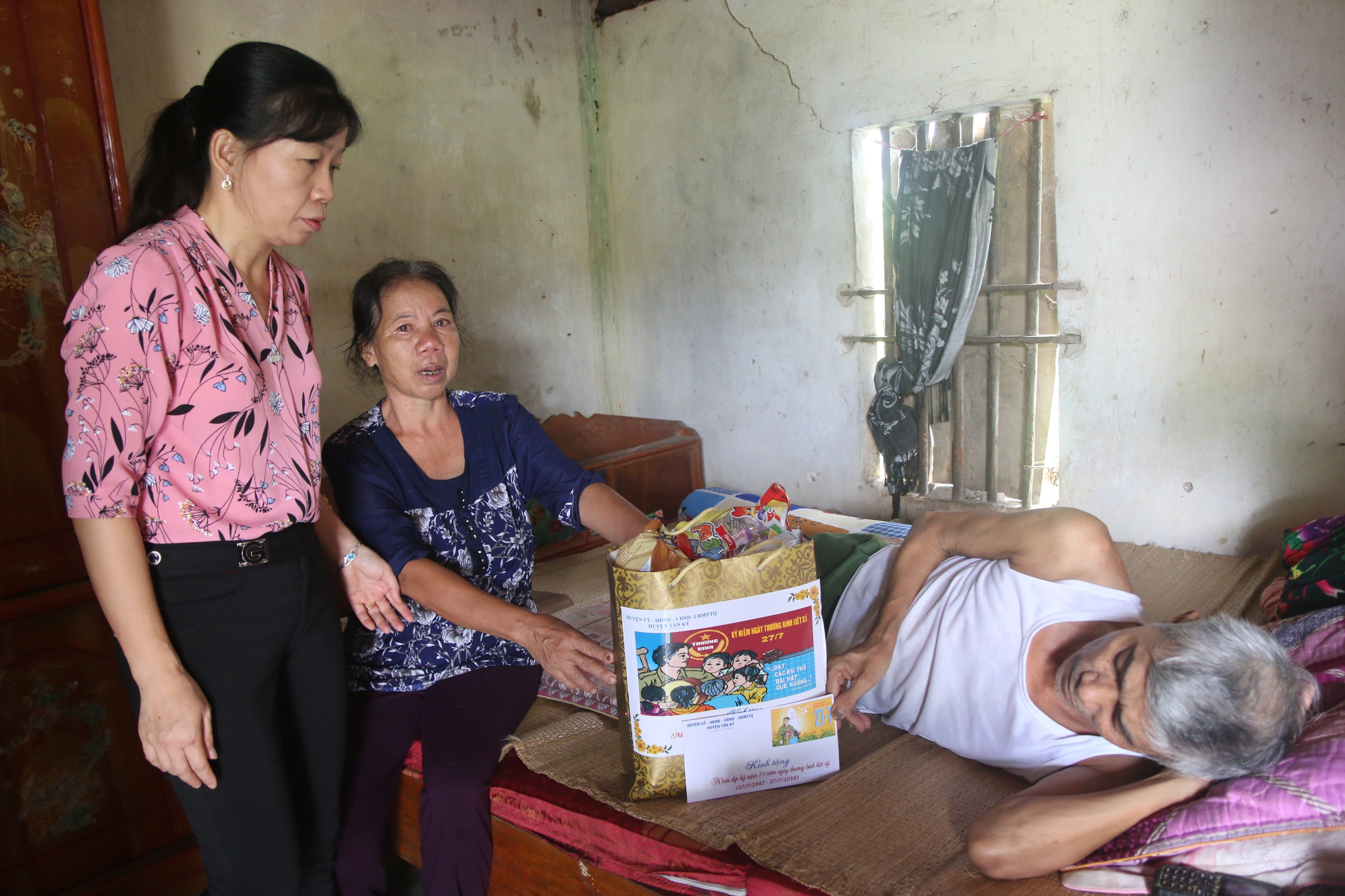 Bà Nguyễn Thị Thêu tặng quà và thăm hỏi động viên thương binh Phùng Quang Minh ở xóm 7 xã Nghĩa Hành