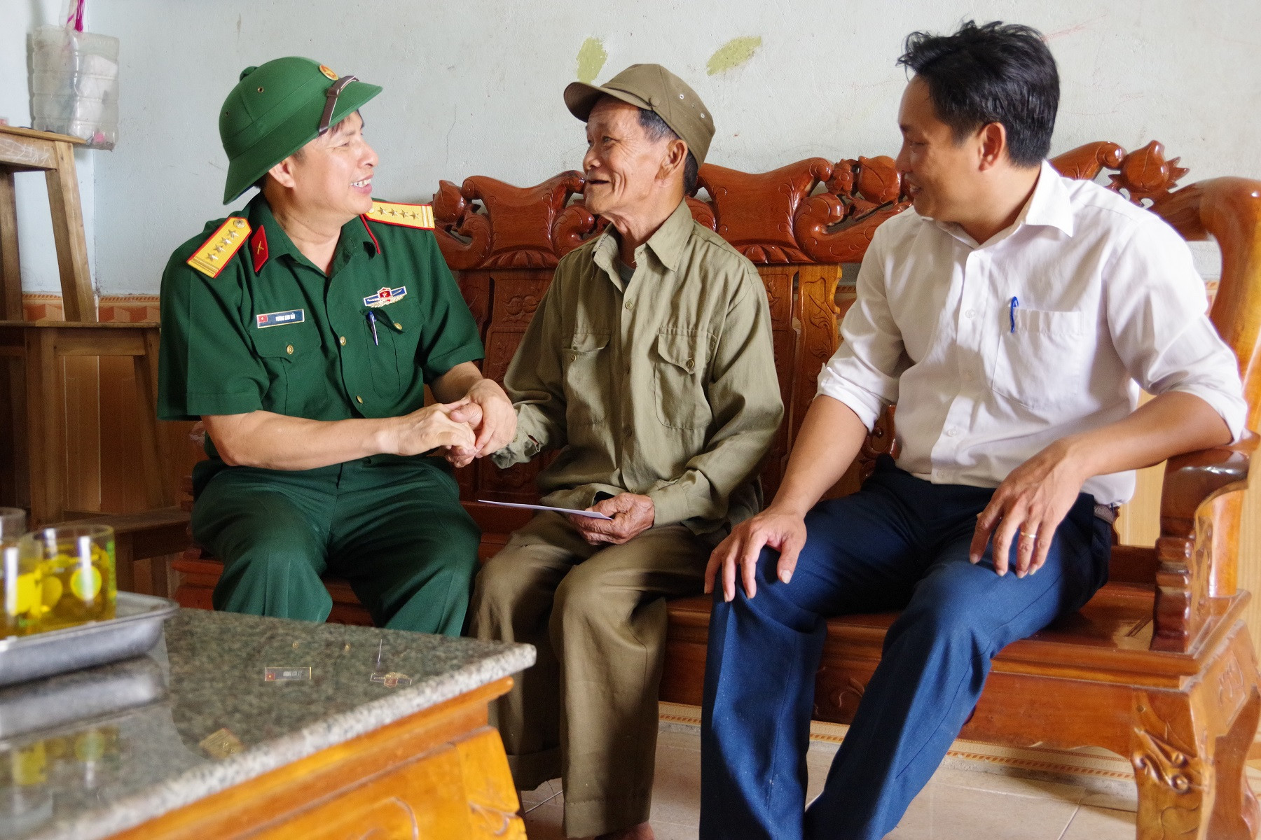 Đại tá Vương Kim Hải - Phó Chính ủy Bộ CHQS tỉnh thăm hỏi, tặng quà cho ông Phạm Hữu Đạt, bị nhiễm chất độc hóa học, bệnh tật hiểm nghèo tại xóm 2 xã Nghi Công Nam. Ảnh: Trọng Kiên