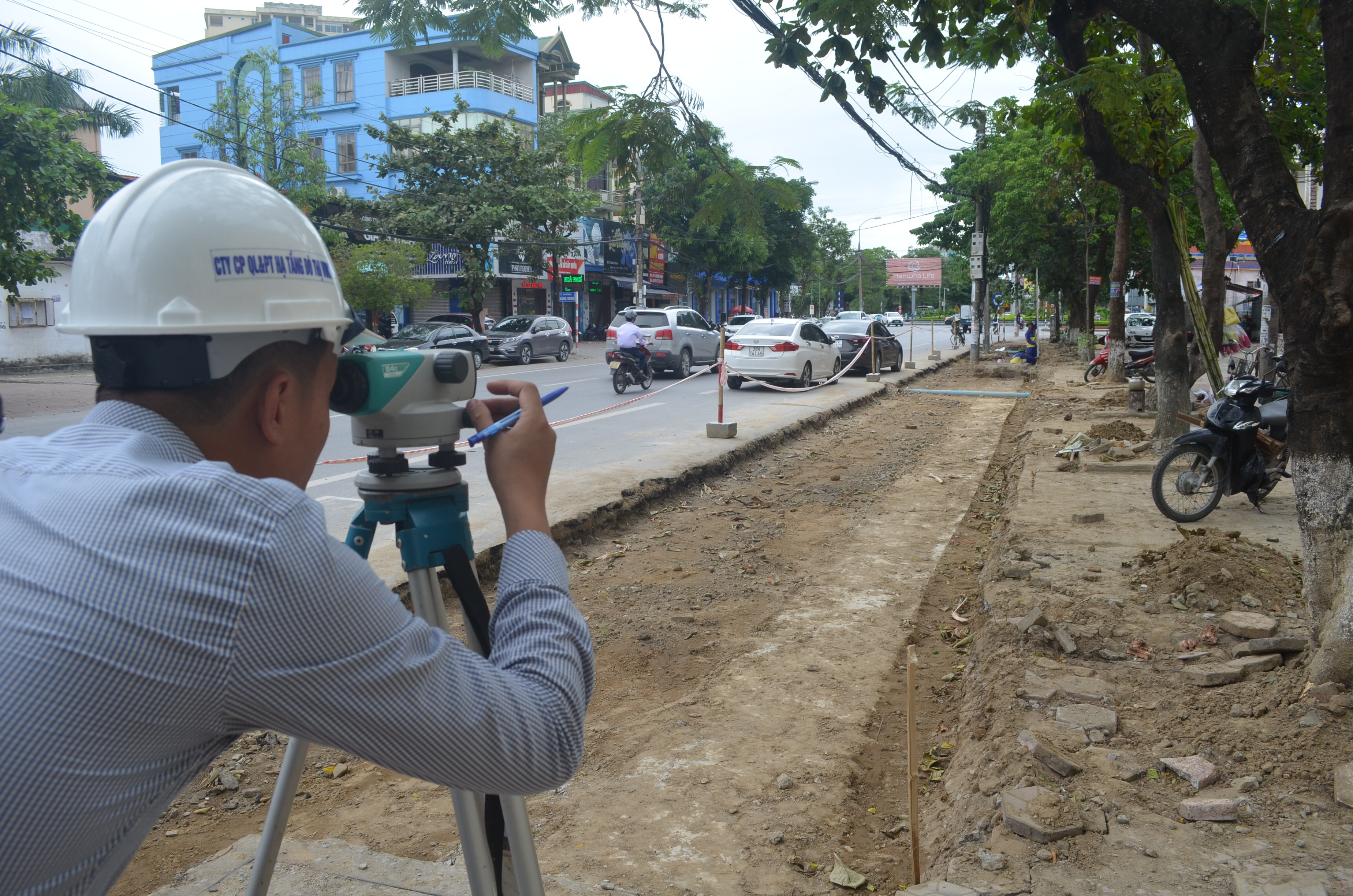 Cán bộ đơn vị hạ tầng đô thị thành phố thực hiện trắc địa trên tuyến đường Nguyễn Thị Minh Khai, đoạn cải tạo vỉa hè làm bãi đậu đỗ ô tô. Ảnh Nhật Lân.