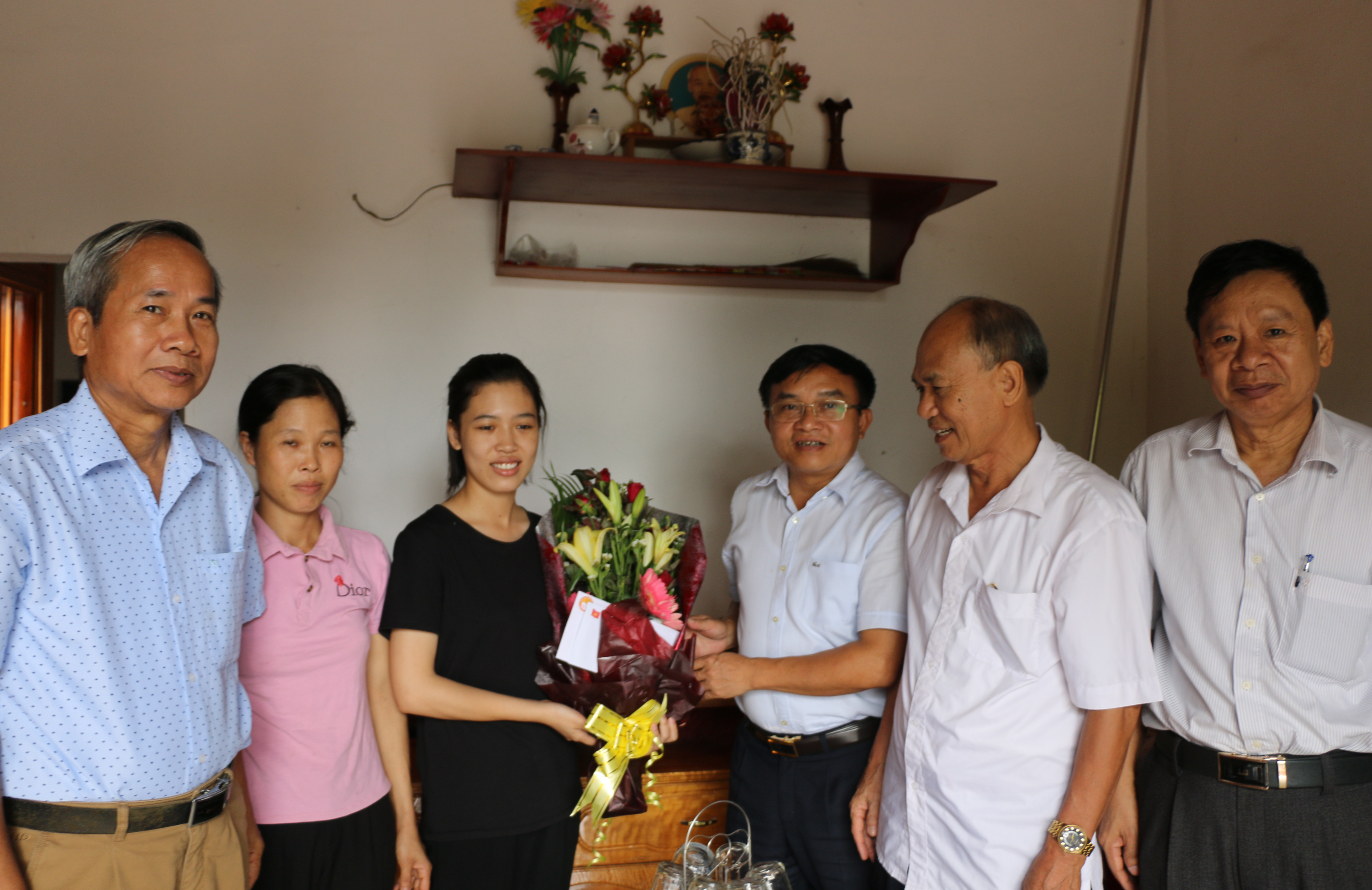 Lãnh đạo huyện chúc mừng em Nguyễn Thị Minh - Thủ khoa khối A1 của tỉnh. Ảnh: Hữu Hoàn