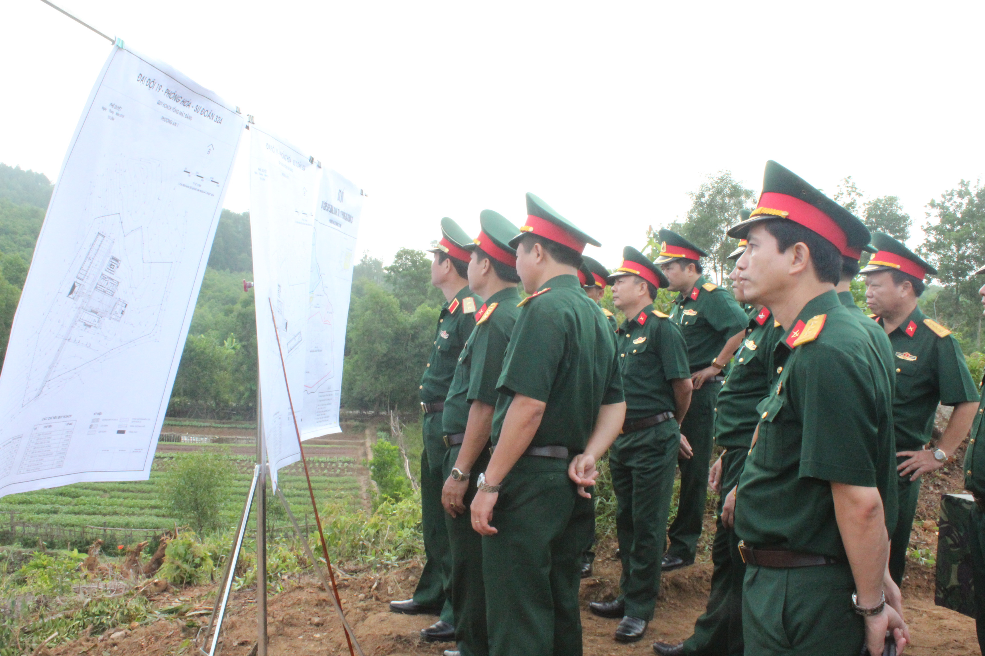 Trung tướng Nguyễn Tân Cương, Ủy viên Trung ương Đảng, Tư lệnh Quân khu cùng đoàn công tác đang kiểm tra bản đồ thiết kế, quy hoạch xây dựng doanh trại của Đại đội 19 hóa học tại xã Nhân Sơn, Đô Lương