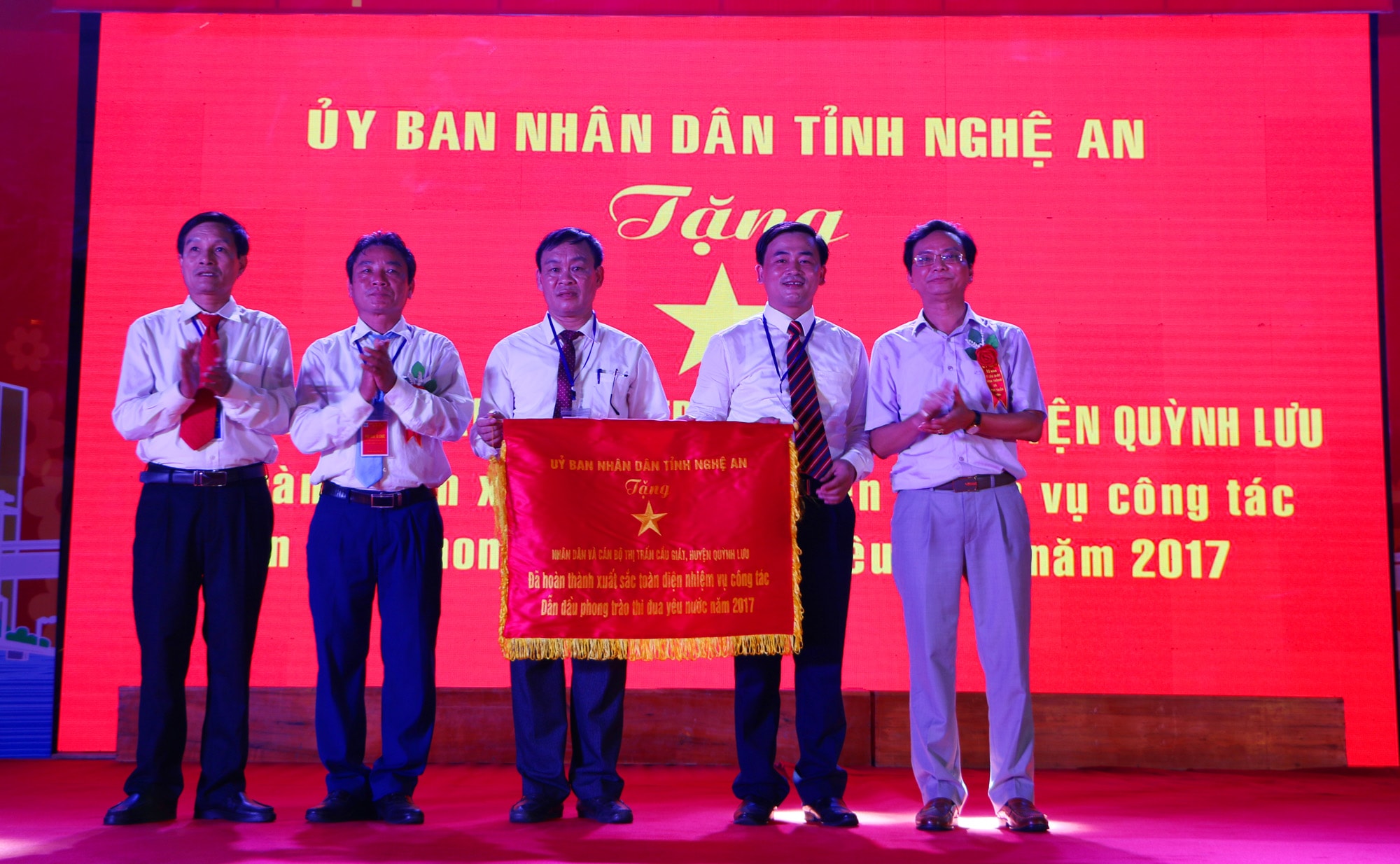 Trao Cờ thi đua xuất sắc của Chủ tịch UBND tỉnh cho Đảng bộ, chính quyền và nhân dân thị trấn Cầu Giát. Ảnh: Nguyễn Hải