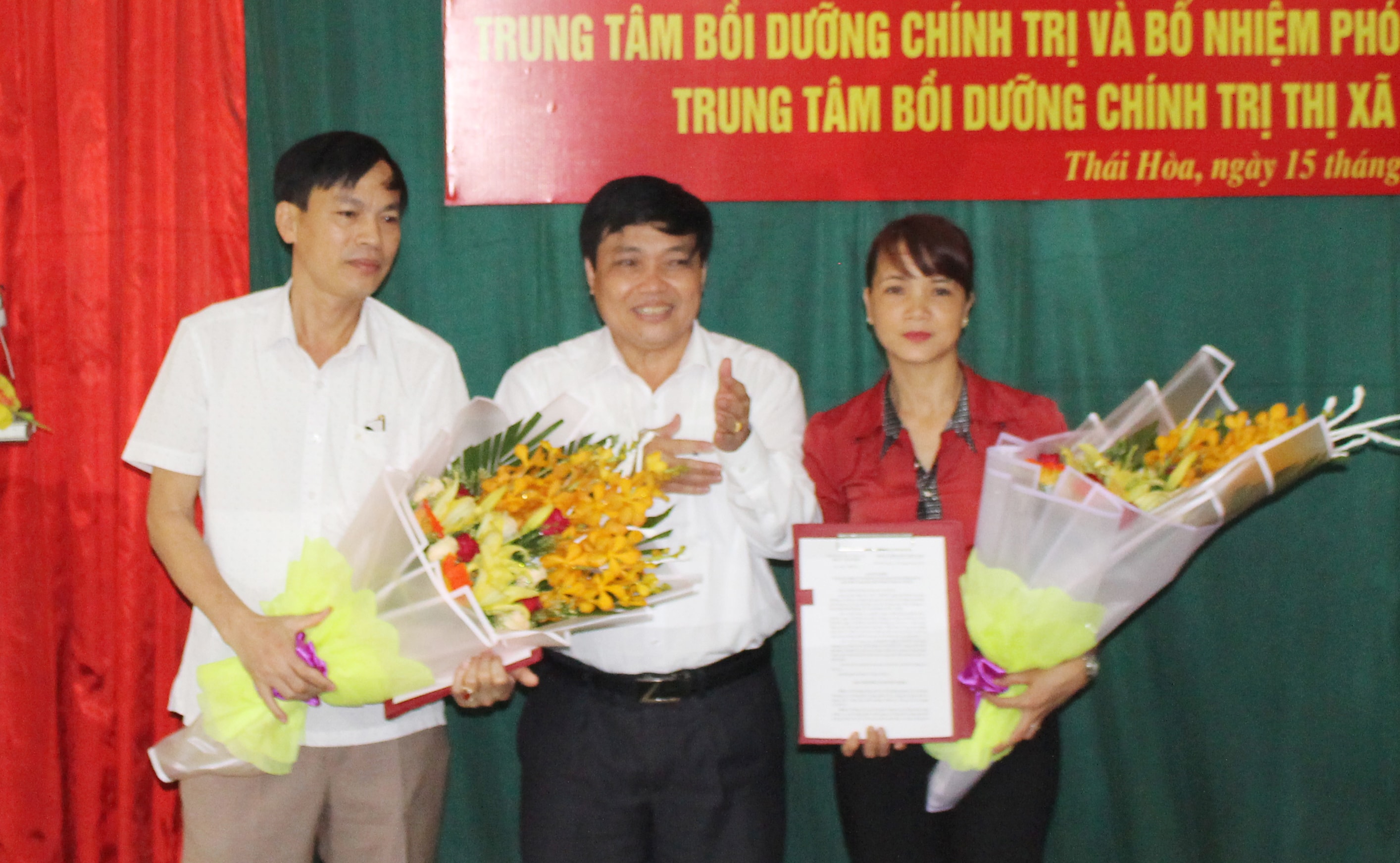 Đồng chí Phạm Quang Toản - Phó Bí thư Thường trực Thị ủy, Chủ tịch HĐND thị xã Thái Hòa trao quyết định và tặng hoa chúc mừng các đồng chí nhận nhiệm vụ mới. Ảnh: Hoàng Thủy