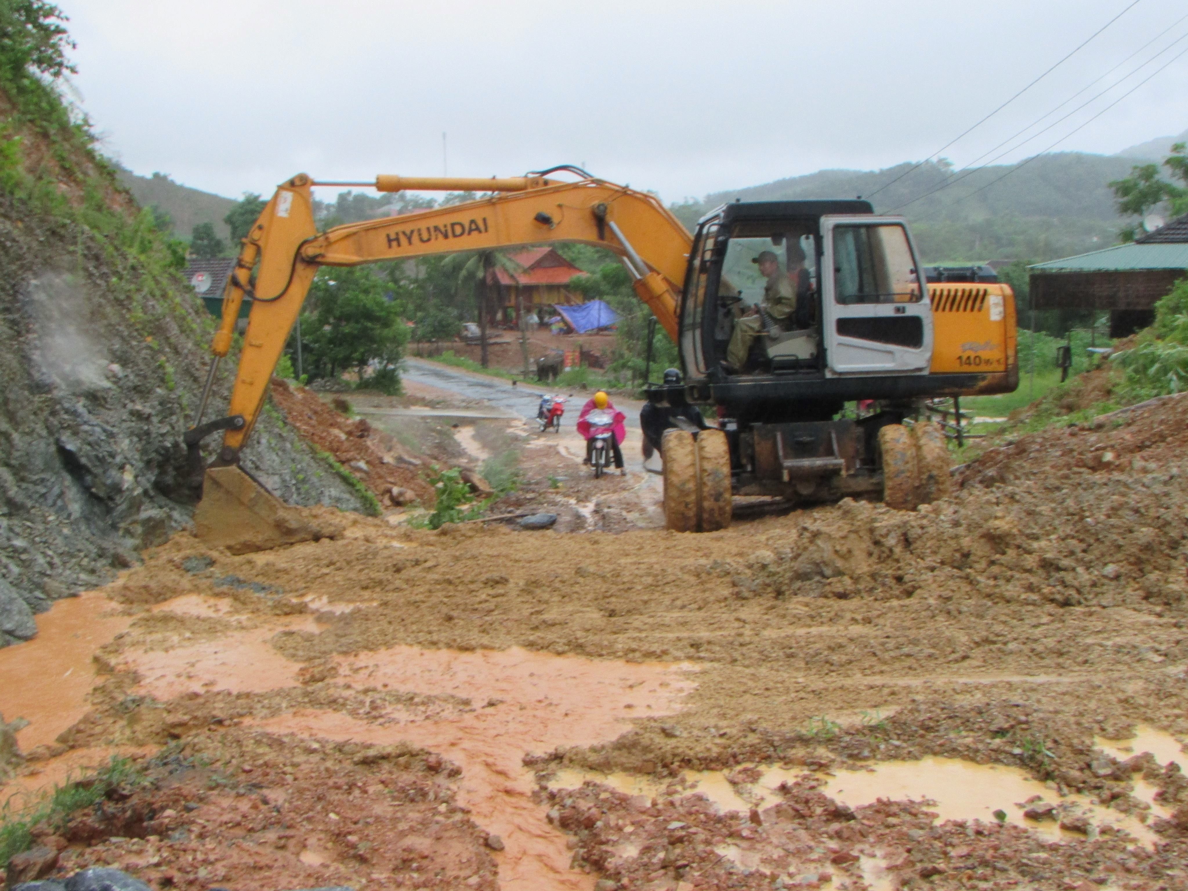 Chính quyền địa phương huy động máy móc đến điểm sạt lở ở Mậu Đức giả tỏa ách tắc. Ảnh : Bá Hậu