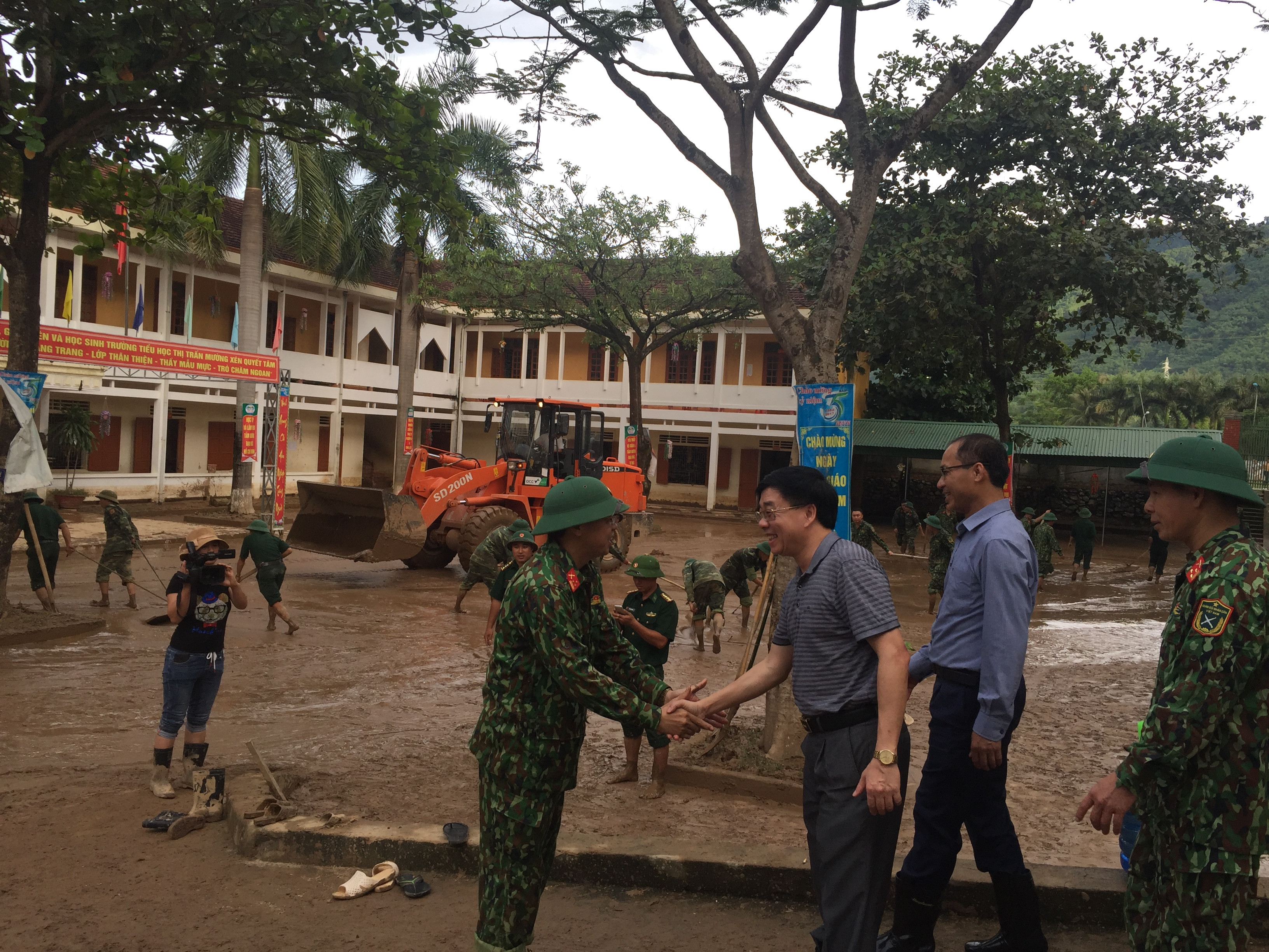 Phó Bí thư Tỉnh ủy Nguyễn Văn Thông thăm hỏi, động viên các lực lượng tham gia hỗ trợ người dân và Trường Tiểu học Thị trấn Mường xén khắc phục hậu quả  lũ lụt. Ảnh: Nguyễn Đình