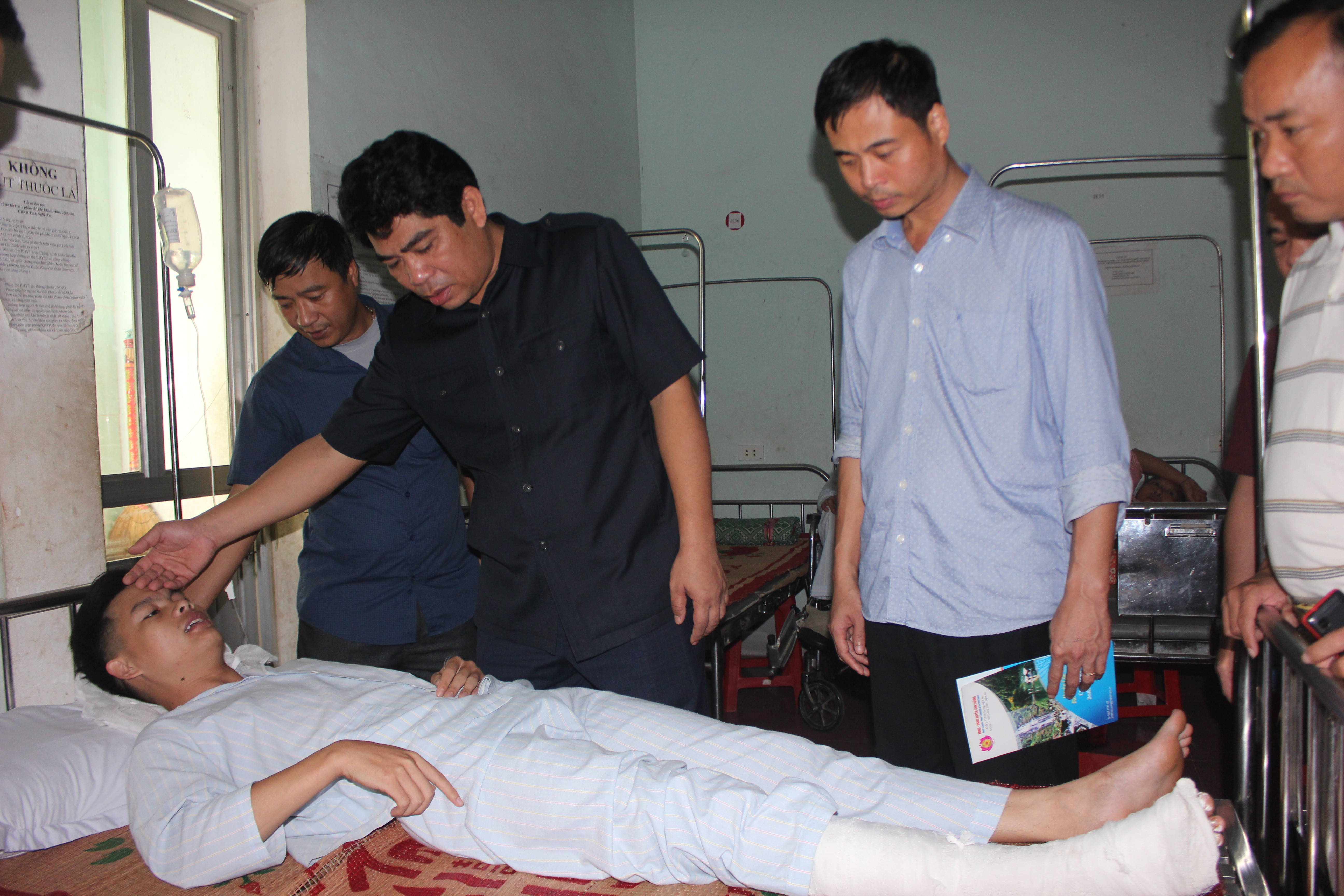 Lãnh đạo huyện Con Cuông thăm hỏi hai chiến sỹ công an bị thương trong lúc di dời tài sản cho dân khỏi vùng ngập lụt. Ảnh: Tường Vy