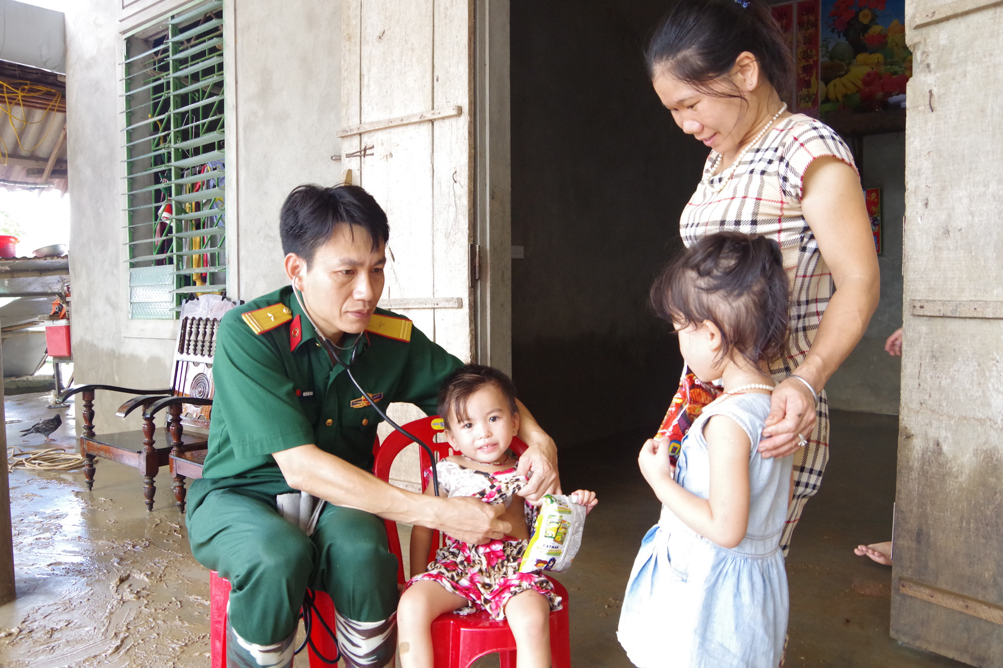 Lực lượng quân y khám bệnh cho các người dân vùng lũ tại xã Bồng Khê huyện Con Cuông. Ảnh: Hoàng Long