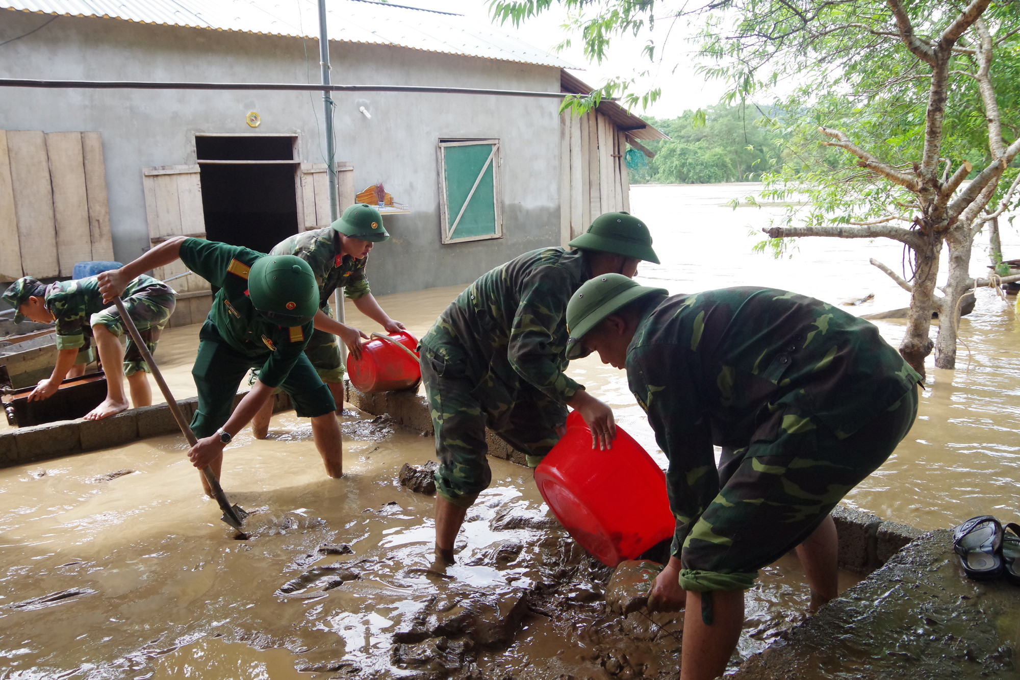 Ban CHQS huyện Con Cuông tổ chức dọn dẹp nhà cửa giúp dân sớm ổn định cuộc sống. Ảnh: Hoàng Long