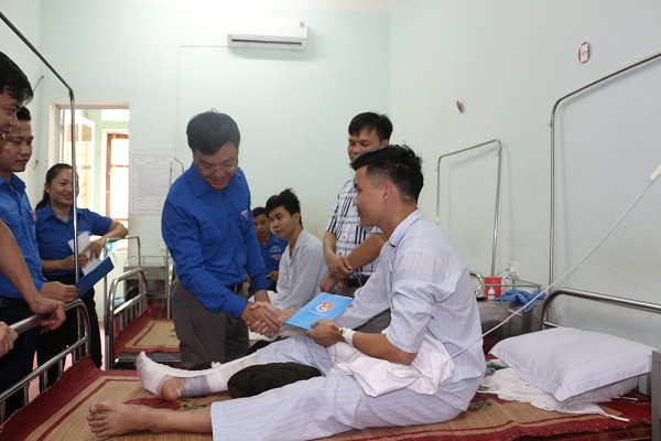 Đồng chí Phạm Tuấn Vinh thăm hỏi 2 chiến sỹ thuộc Đội Cảnh sát PCCC số 6 bị thương trong lúc giúp dân chạy lũ. Ảnh: Quang Thành