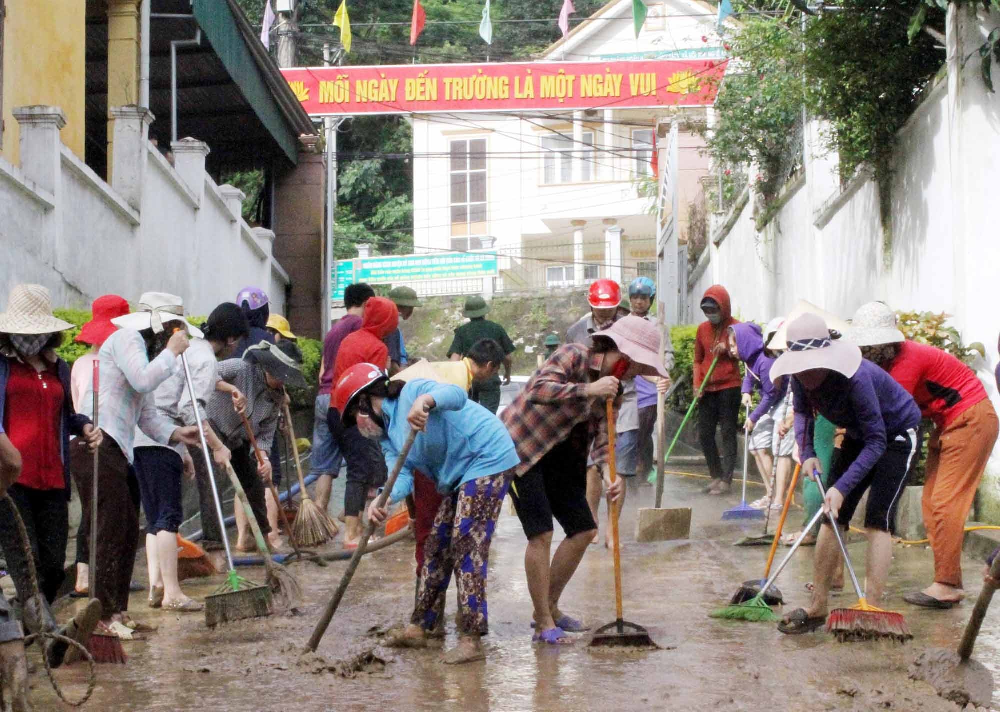 Giáo viên và phụ huynh khắc phục mưa lũ ở Trường Tiểu học thị trấn Mường Xén (Kỳ Sơn). Ảnh: MH