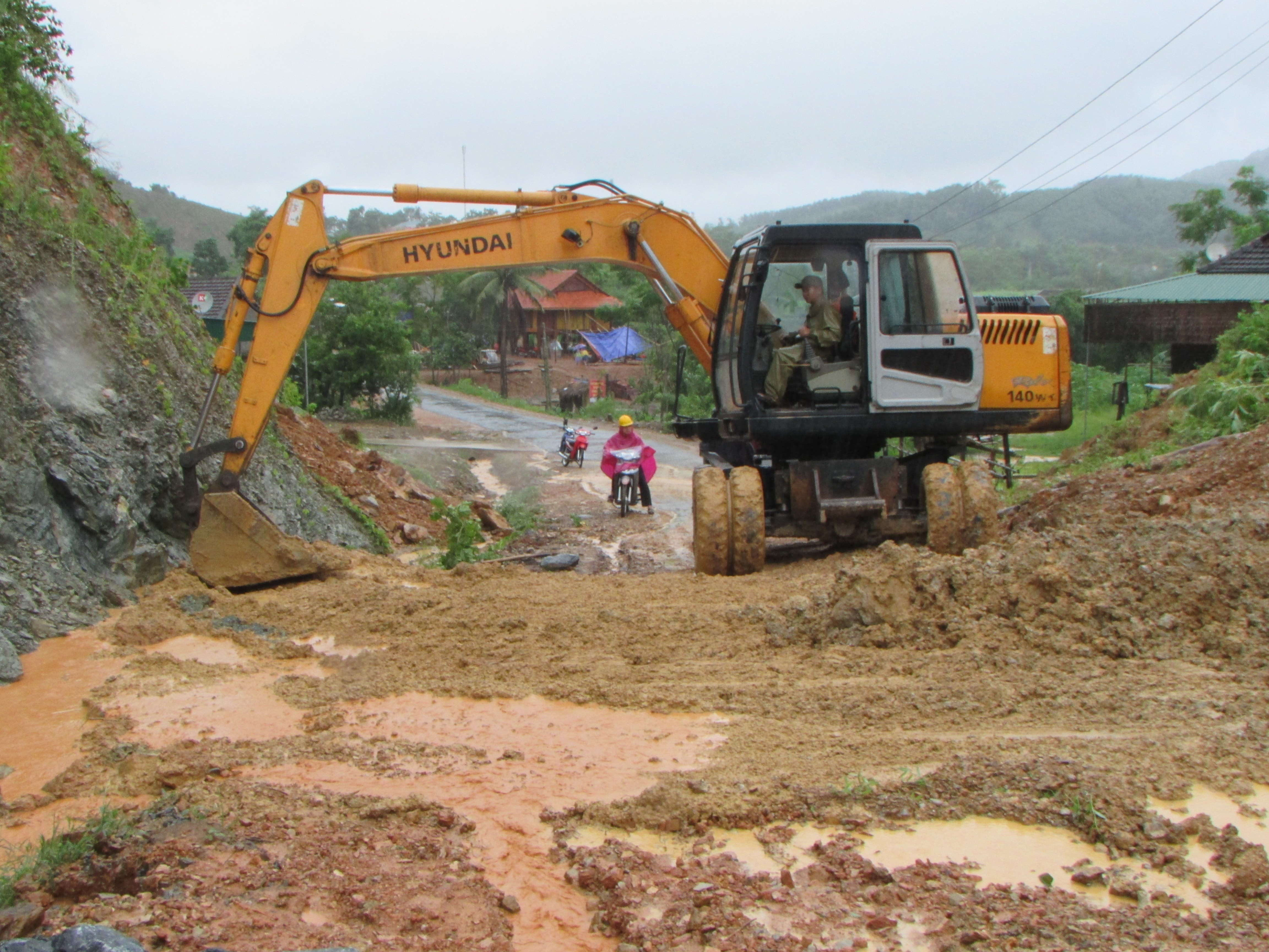 Huyện Con Cuông đã huy động nhân lực và máy móc khơi thông tuyến đường Mậu Đức đi Thạch Ngàn. Ảnh: Vi Nhẫn    