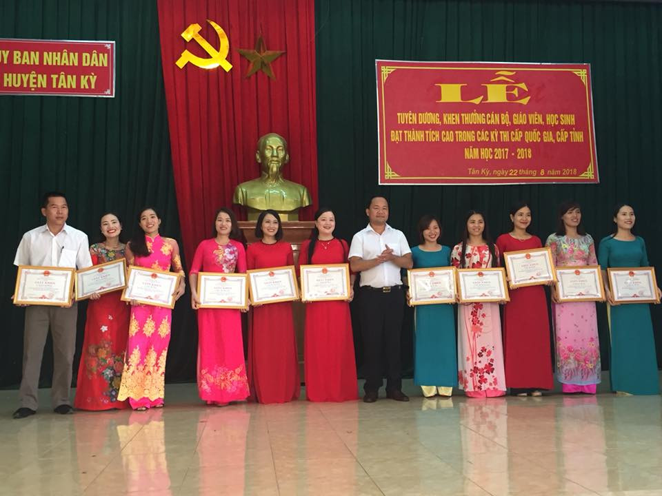 Đồng chí Hoàng Quốc Việt - Chủ tịch UBND huyện Tân Kỳ trao giấy khen cho các giáo viên đạt thành tích cao. Ảnh: Bông Mai