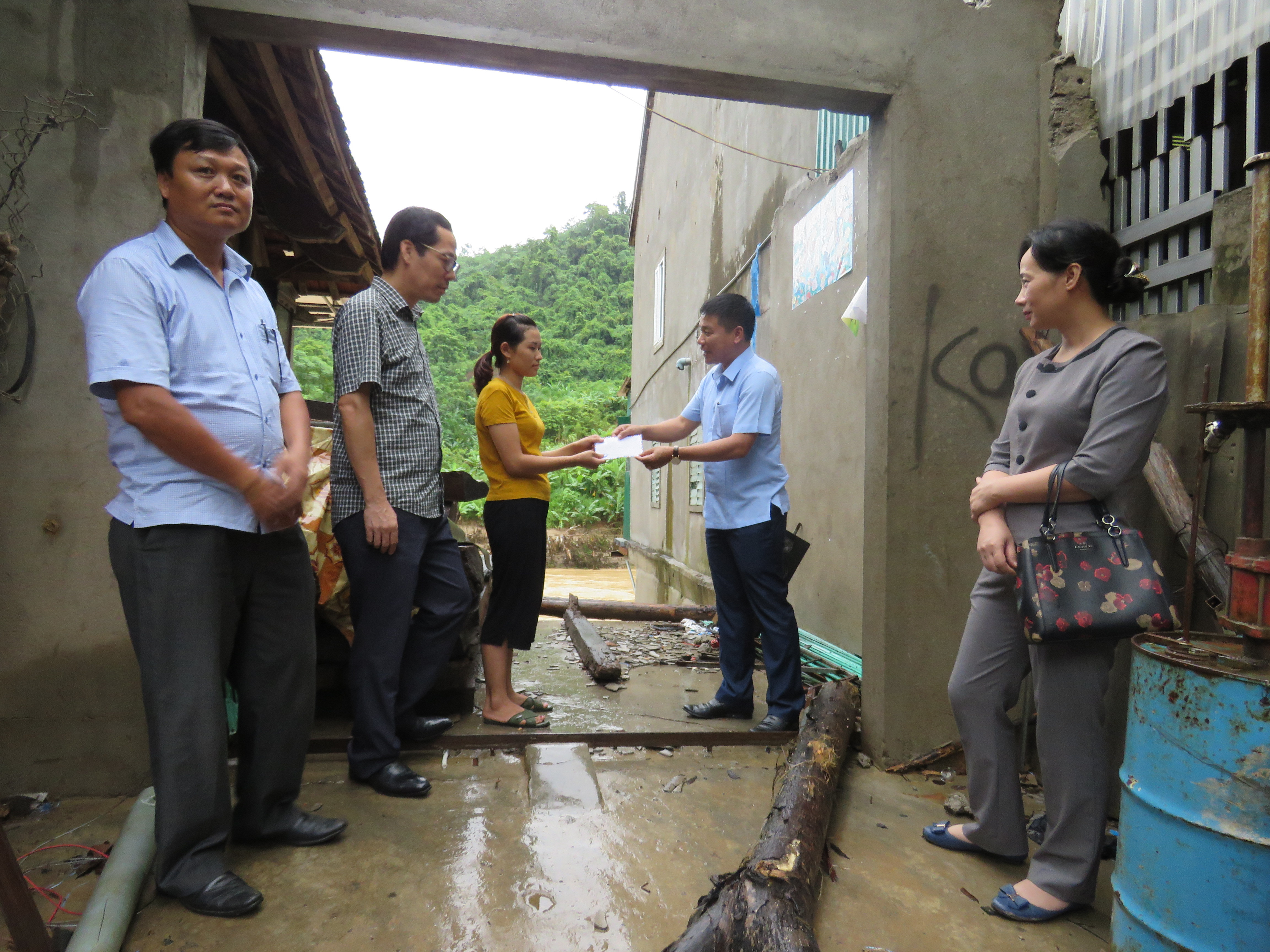 Đoàn thăm và tặng quà cho gia đình nghèo bị ảnh hưởng bởi bão số 4 trên địa bàn thị trấn Mường Xén. Ảnh: Duy Thành