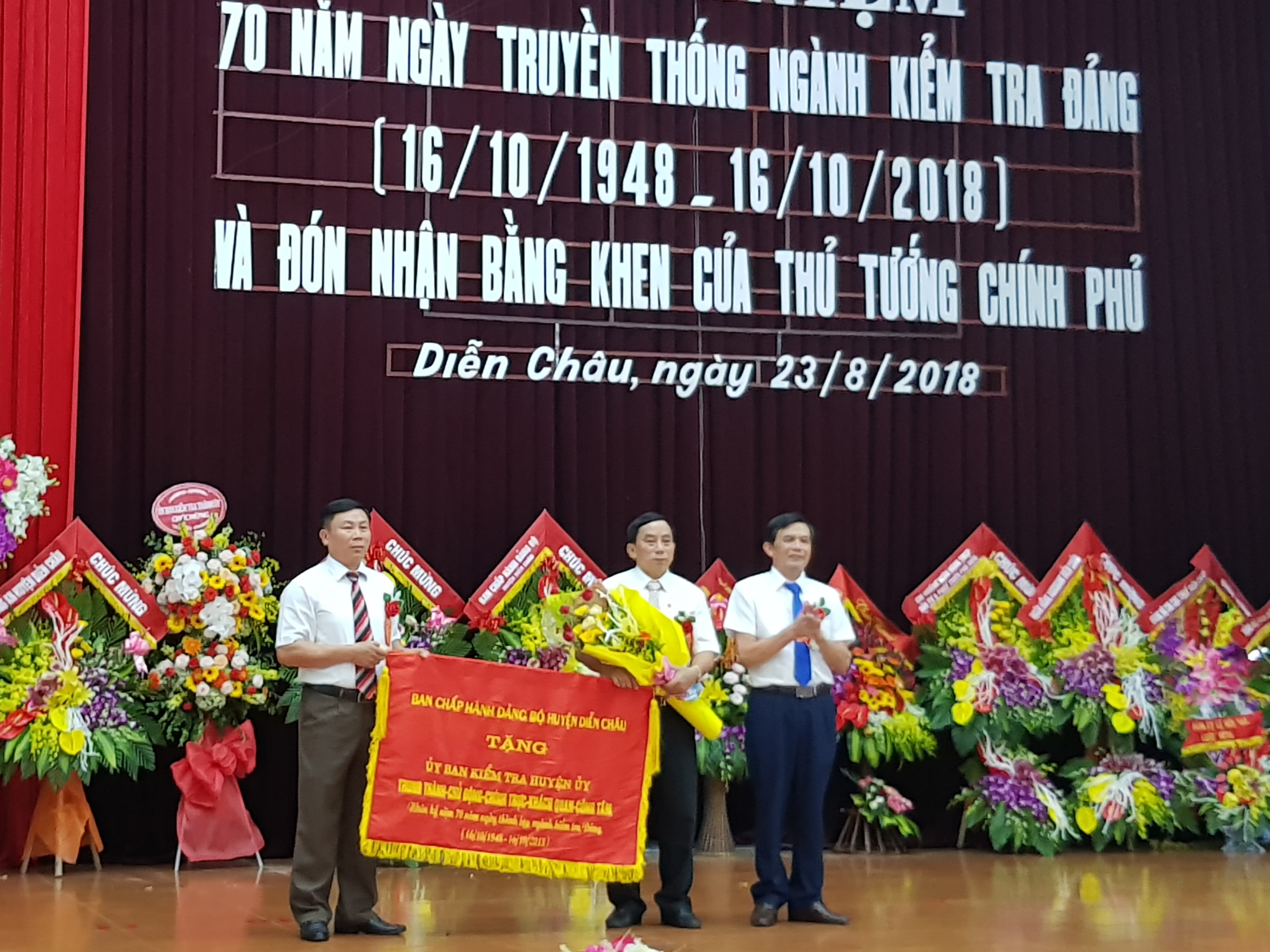 Đồng chí Trần Văn Cương – Bí thư Huyện ủy trao tặng bức trướng cho UBKT Huyện ủy Diễn Châu. Ảnh: Vân Anh