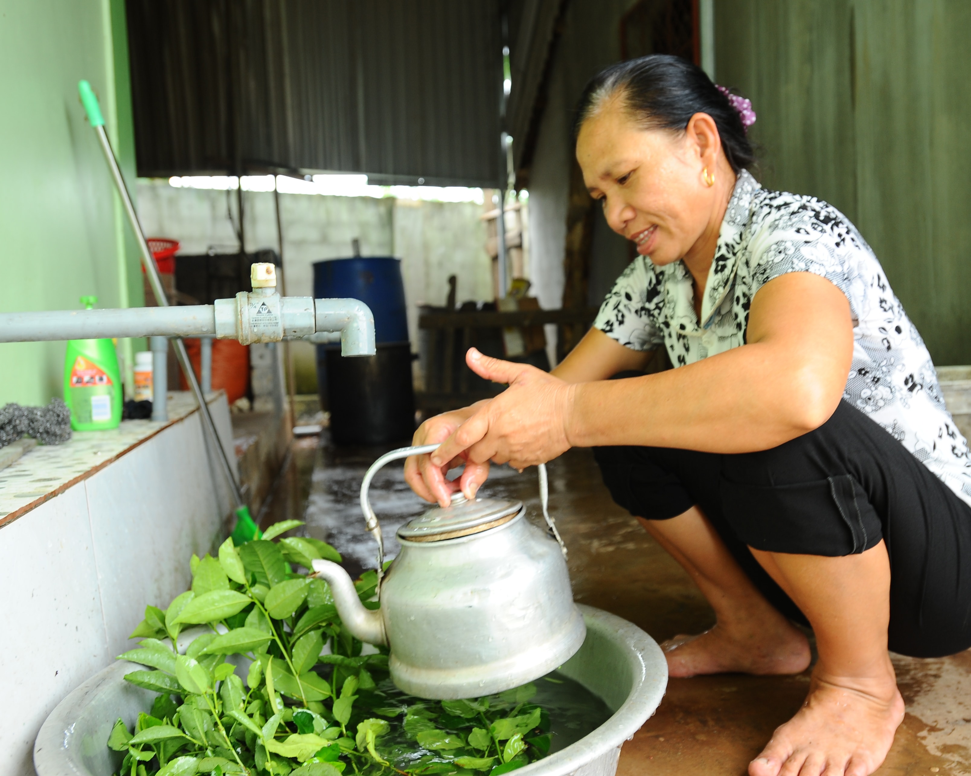 Bà Phan Thị Hà đang chuẩn bị om nước chè phục vụ bà con, làng xóm sang cổ vũ cho Olympic Việt Nam. Ảnh: Thành Cường