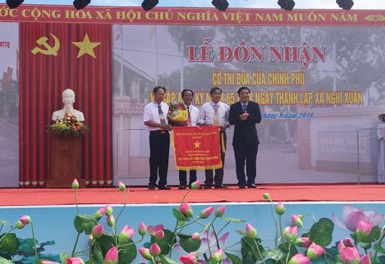 Đồng chí Nguyễn Đắc Vinh - Ủy viên TW Đảng, Bí thư tỉnh ủy trao cờ thi đua Chính phủ cho Nghi Xuân.