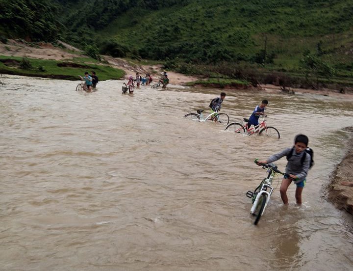 Các em học sinh bản Kẻ Tre, xã Thạch Ngàn vất vả vượt qua khe để đến trường học. Ảnh: Minh Hạnh