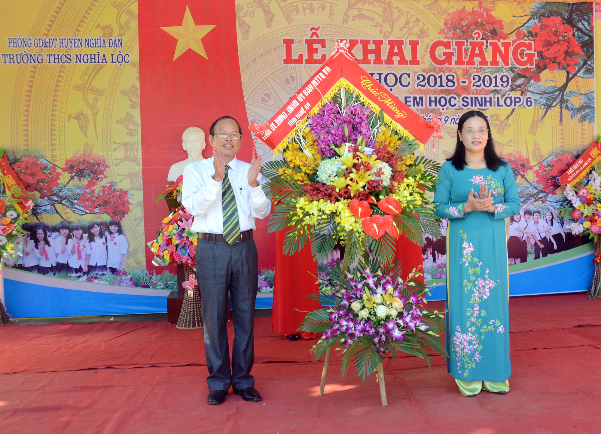 Đồng chí Cao Thị Hiền tặng hoa chúc mừng cho Trường THCS Nghĩa Lộc trong buổi lễ khai giảng. Ảnh: Thành Chung