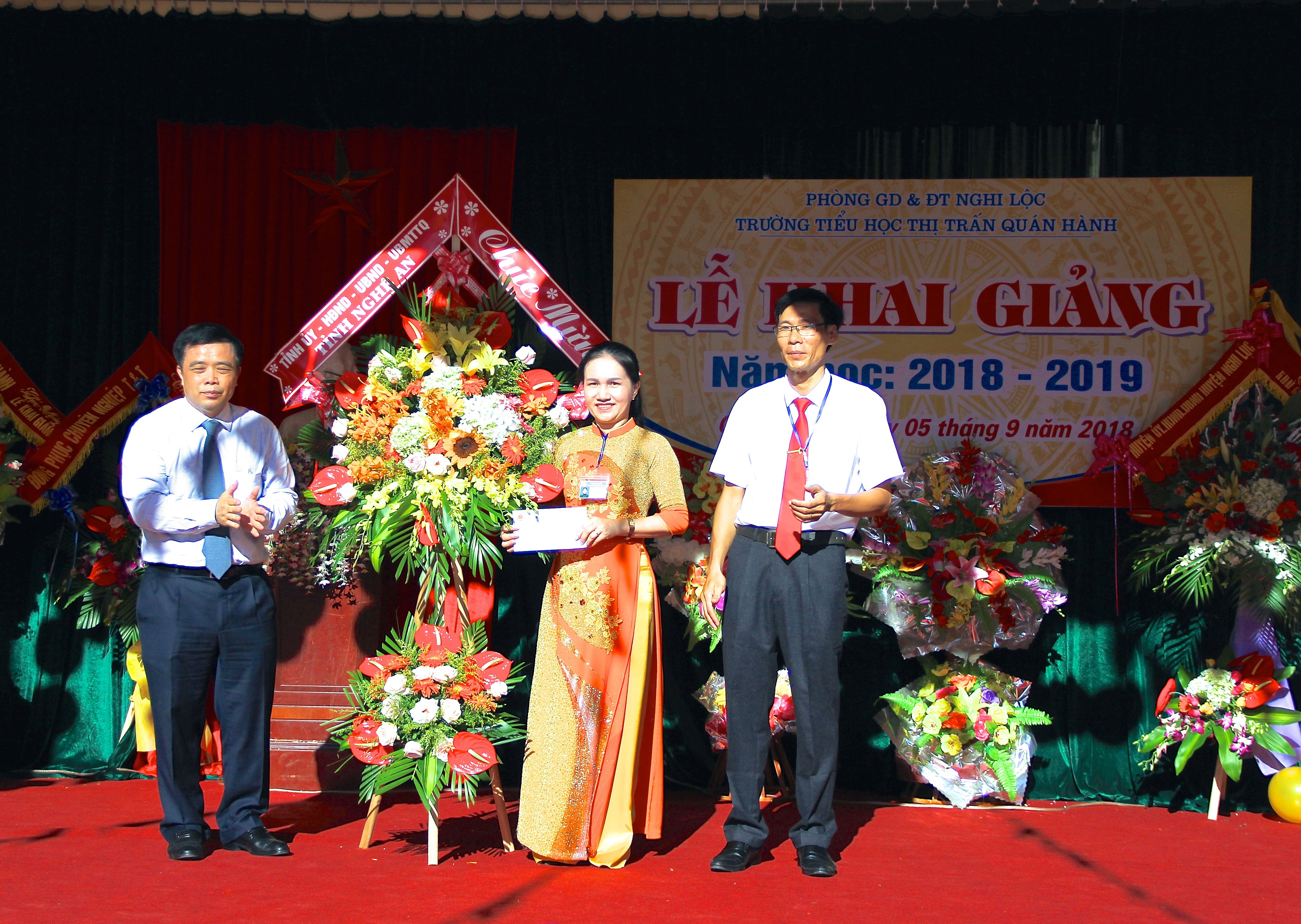Phó Chủ tịch UBND tỉnh Huỳnh Thanh Điền trao tặng lẵng hoa và quà cho nhà trường. Ảnh: Mỹ Nga
